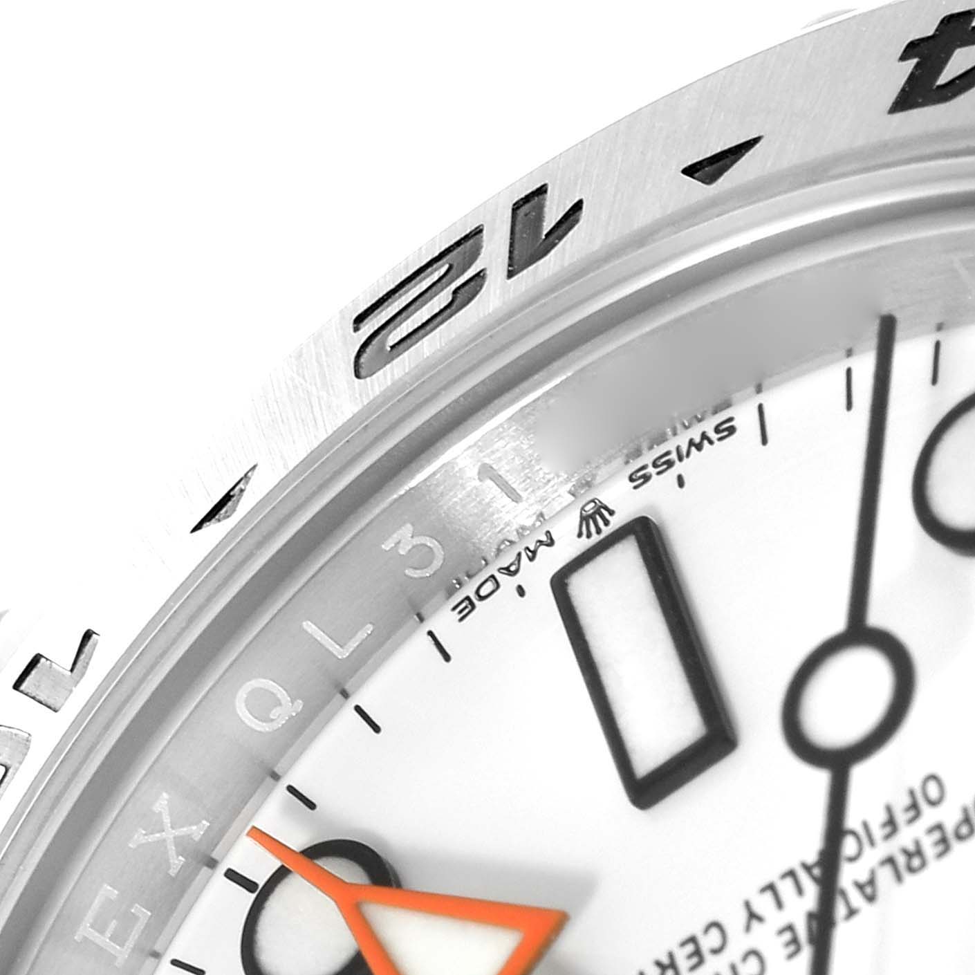 Close-up of a Rolex Explorer 226570 Men
s Stainless Steel White Dial 226570 Men
s Stainless Steel White Dial watch showing part of the dial, orange hand, bezel with 12, and "Swiss Made" text.