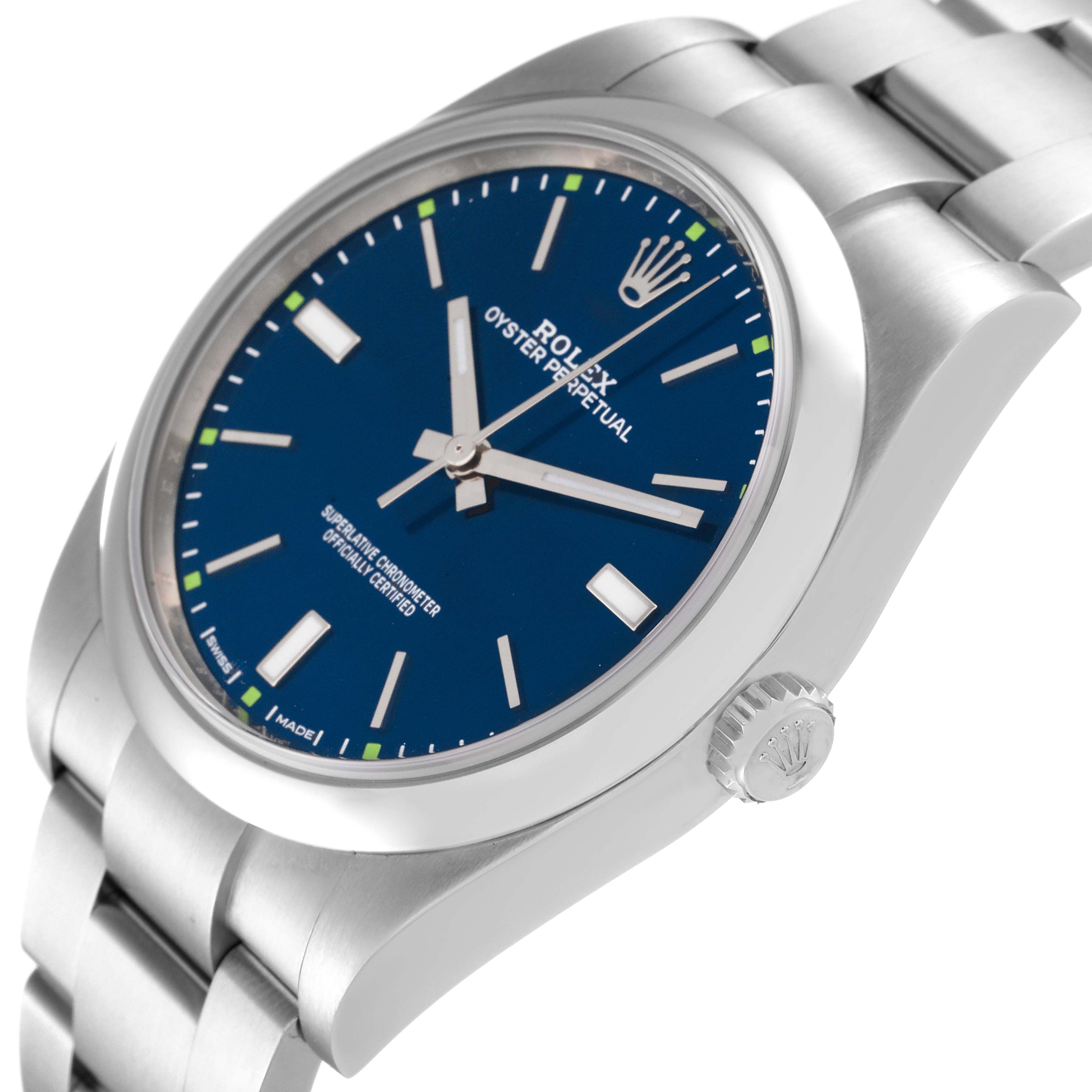 The image shows a Rolex Oyster Perpetual 114300 Men's Stainless Steel Blue Dial 114300 Men's Stainless Steel Blue Dial watch from an angled side view, highlighting the dial, crown, and bracelet.