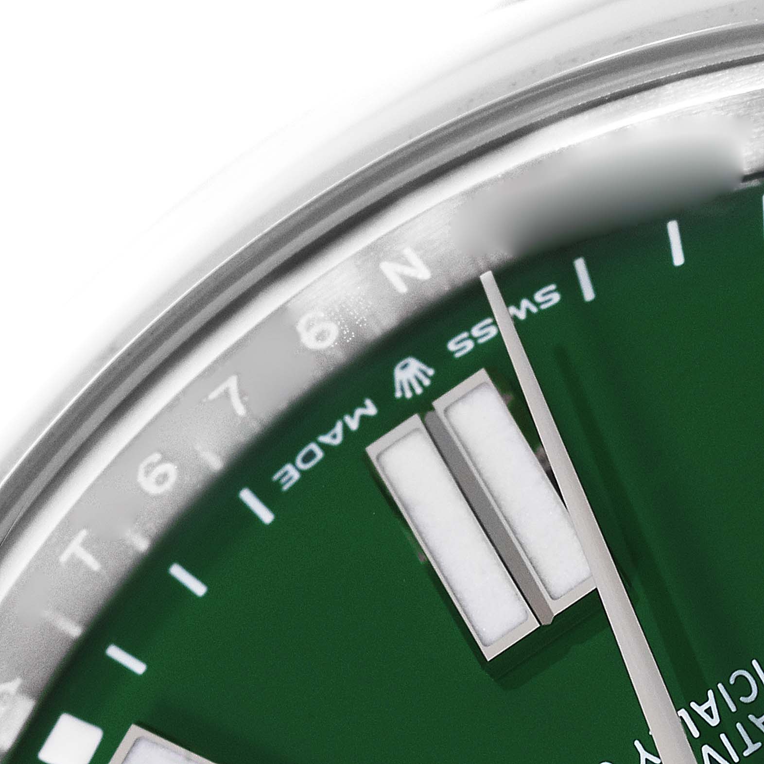 The image shows a close-up of the dial and part of the bezel from a Rolex Oyster Perpetual 124300 Men
s Stainless Steel Green Dial 124300 Men
s Stainless Steel Green Dial watch, focusing on the hour markers, hands, and branding.