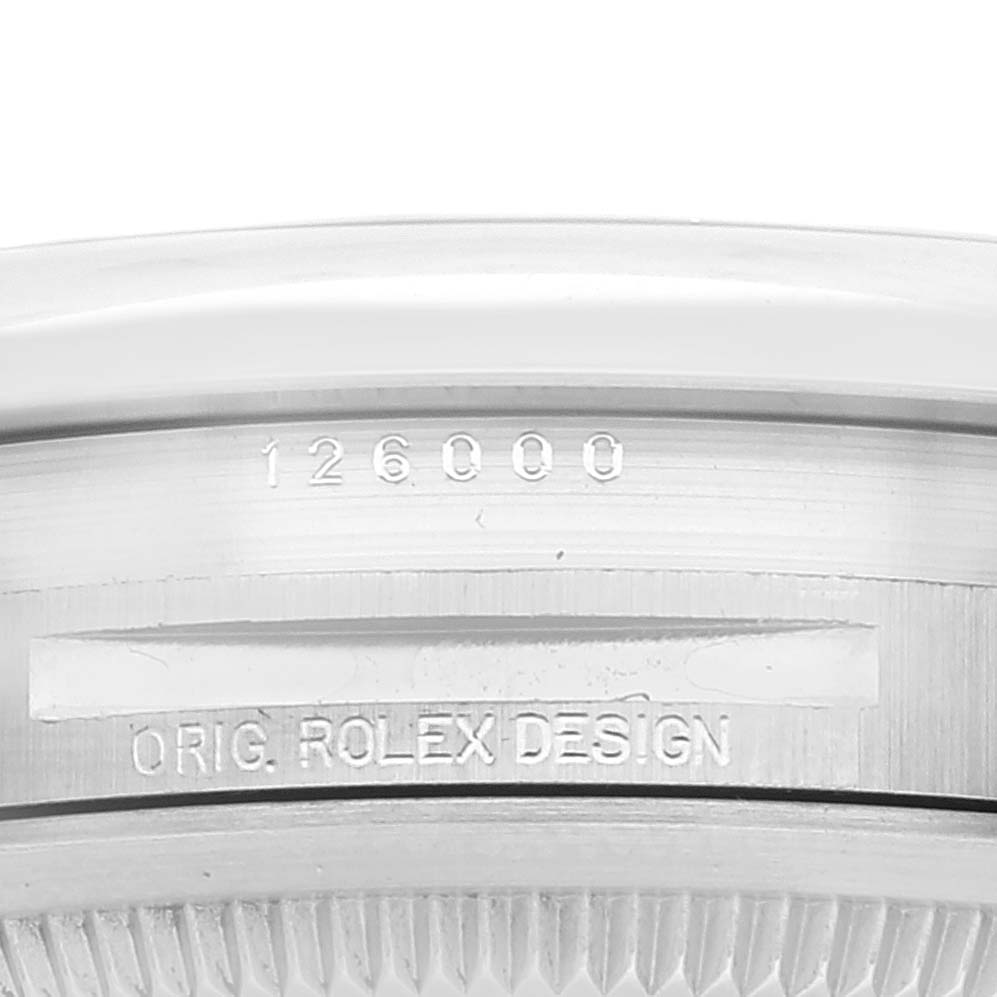 This image shows a close-up of the side of a Rolex Oyster Perpetual 126000 Men
s Stainless Steel Blue Dial 126000 Men
s Stainless Steel Blue Dial watch case, displaying the model number 126000 and "ORIG. ROLEX DESIGN" engraving.