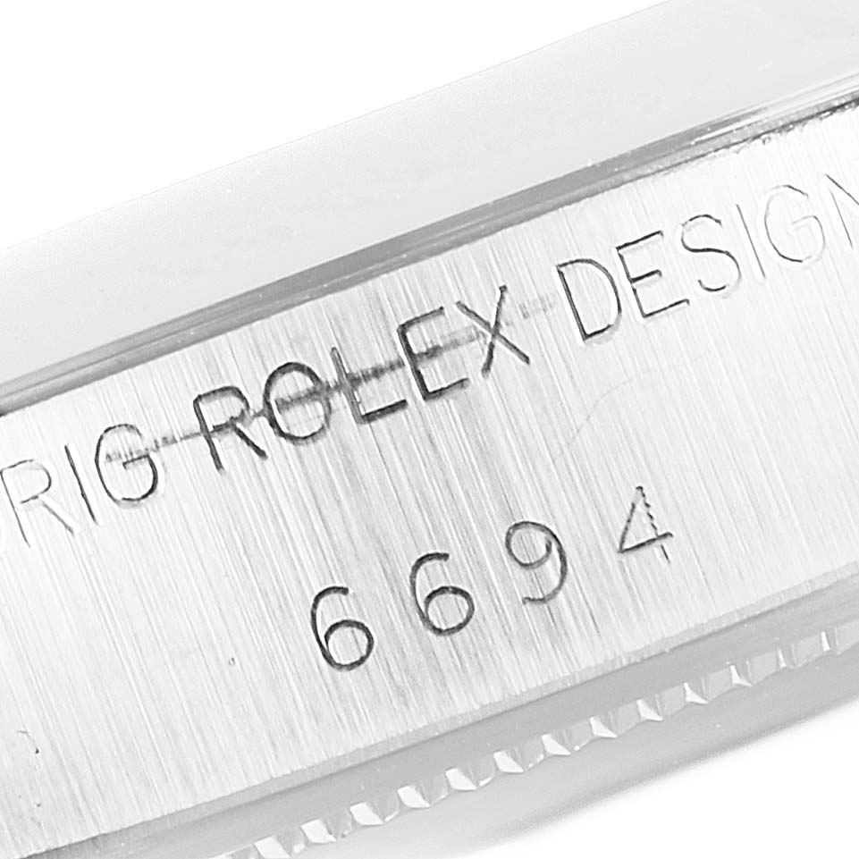 This image shows the engraved side of a Vintage Collection model by Rolex, focusing on the serial number and brand name.
