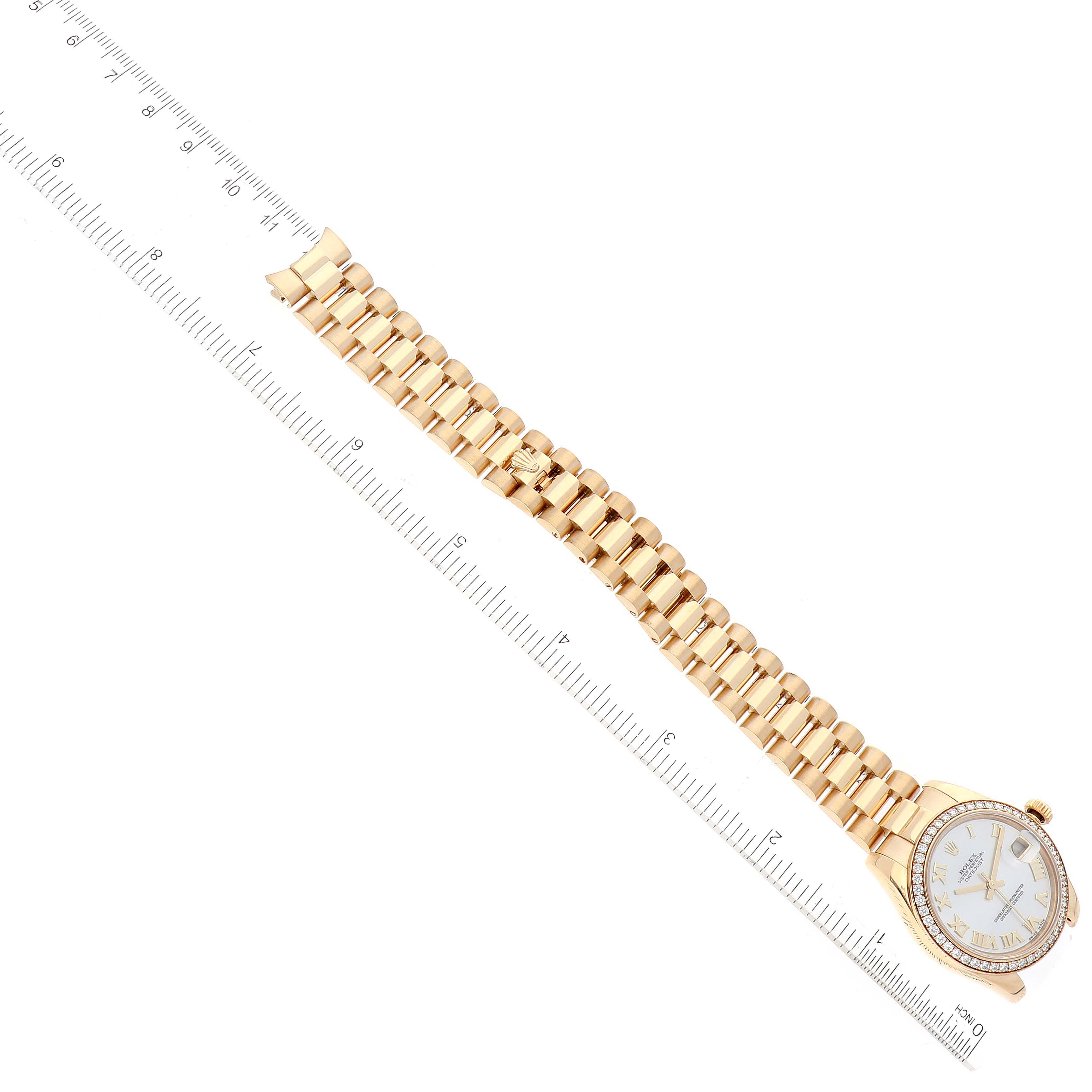 This image shows the Rolex President 178288 Women's Yellow Gold Champagne Dial 178288 Women's Yellow Gold Champagne Dial watch laid flat with a ruler beside it, displaying the entire bracelet and watch face.