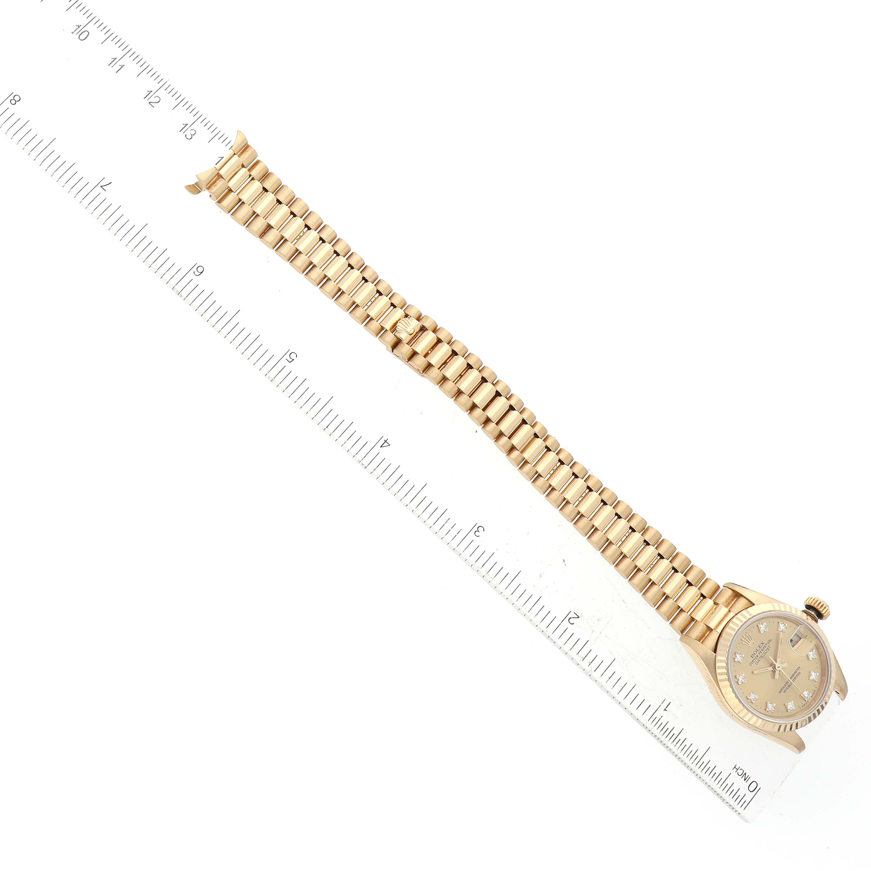The image shows a Rolex President 69178 Women's Yellow Gold Champagne Dial 69178 Women's Yellow Gold Champagne Dial model watch laid flat with its bracelet extended and a ruler for scale.