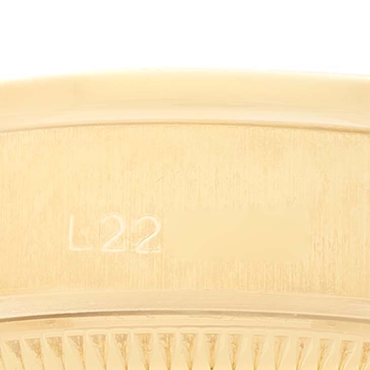 This close-up shows the edge and part of the band of a Rolex President 69138 Women
s Yellow Gold Champagne Dial 69138 Women
s Yellow Gold Champagne Dial model watch, highlighting a visible serial number.