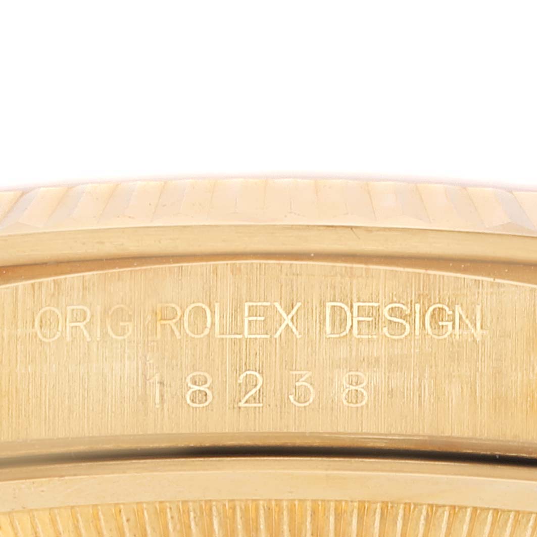 This image shows a close-up of the side of a Rolex President 18238 Men
s Yellow Gold Champagne Dial 18238 Men
s Yellow Gold Champagne Dial model watch with the engraving "ORIG ROLEX DESIGN 18238".