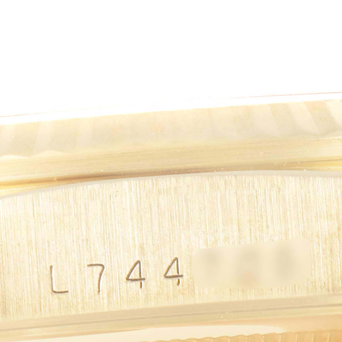 The image shows a close-up of the side of a Rolex President 18238 Men
s Yellow Gold Champagne Dial 18238 Men
s Yellow Gold Champagne Dial model watch, highlighting its serial number engraving.