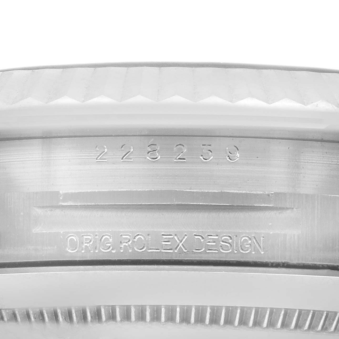 The image shows a close-up of the side of a Rolex President 228239 Men's White Gold Green Dial 228239 Men's White Gold Green Dial model, revealing the serial number and "ORIG. ROLEX DESIGN" engraving.
