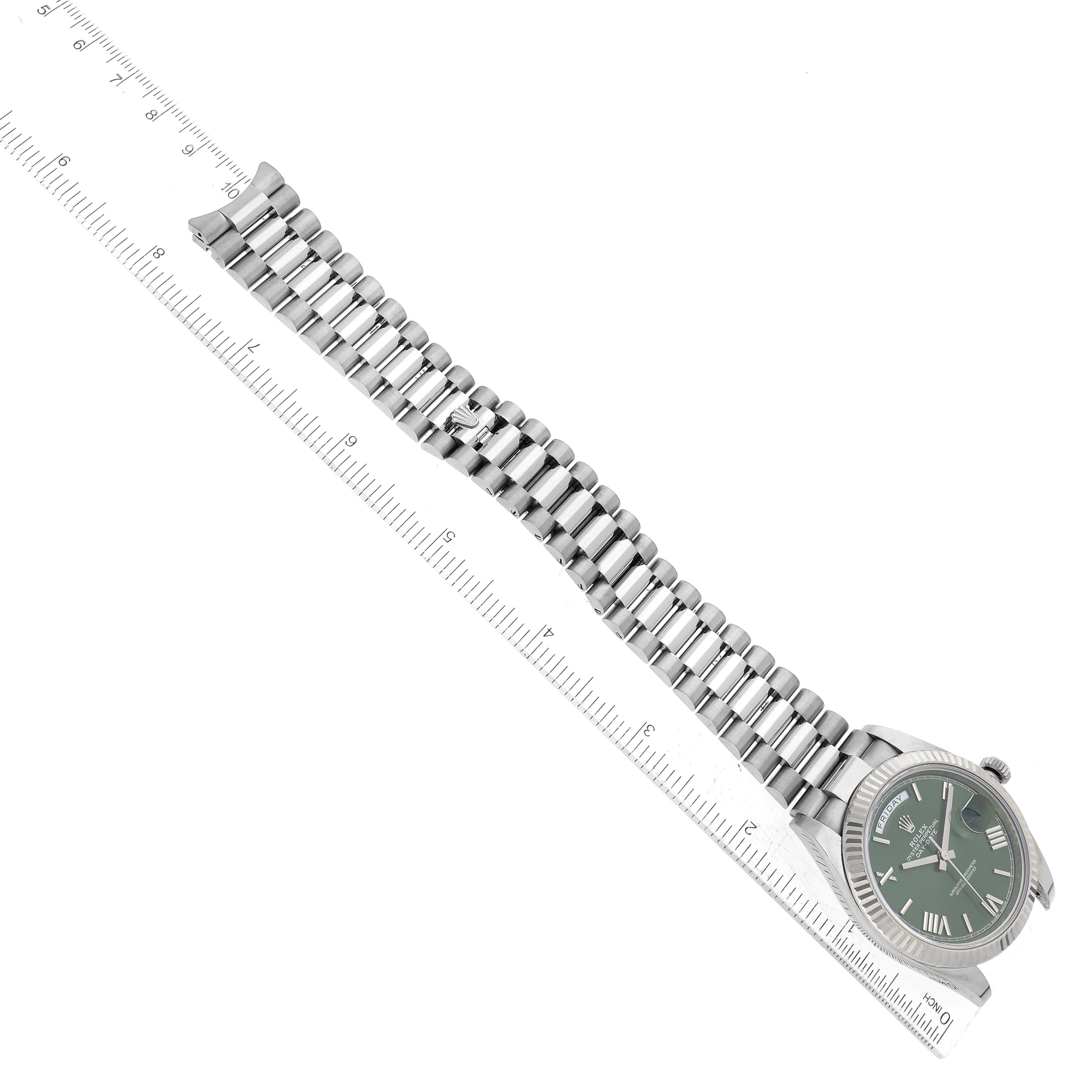 The image shows a Rolex President 228239 Men's White Gold Green Dial 228239 Men's White Gold Green Dial model watch placed next to a ruler, highlighting the watch band and the face at an angle.
