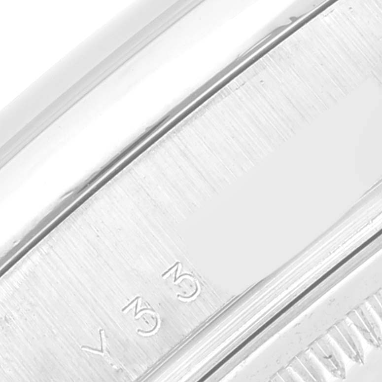 The image shows a close-up of the bezel and part of the case side of a Rolex President 118209 Men's White Gold Silver Dial 118209 Men's White Gold Silver Dial model watch.