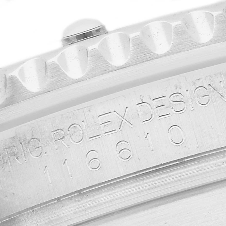 The image shows a close-up of the Rolex Submariner 116610LV Men
s Stainless Steel Green Dial
s side, featuring the bezel edge and engraved design numbers.