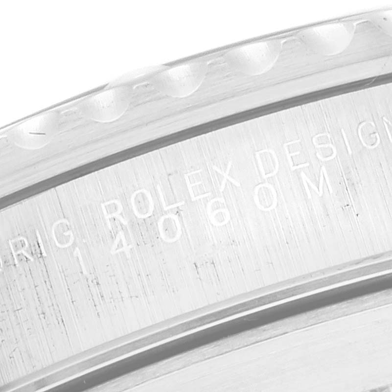 This image shows a close-up of the side engraving on a Rolex Submariner 14060 Men
s Stainless Steel Black Dial 14060 Men
s Stainless Steel Black Dial watch case with "ROLEX DESIGN" and model number.