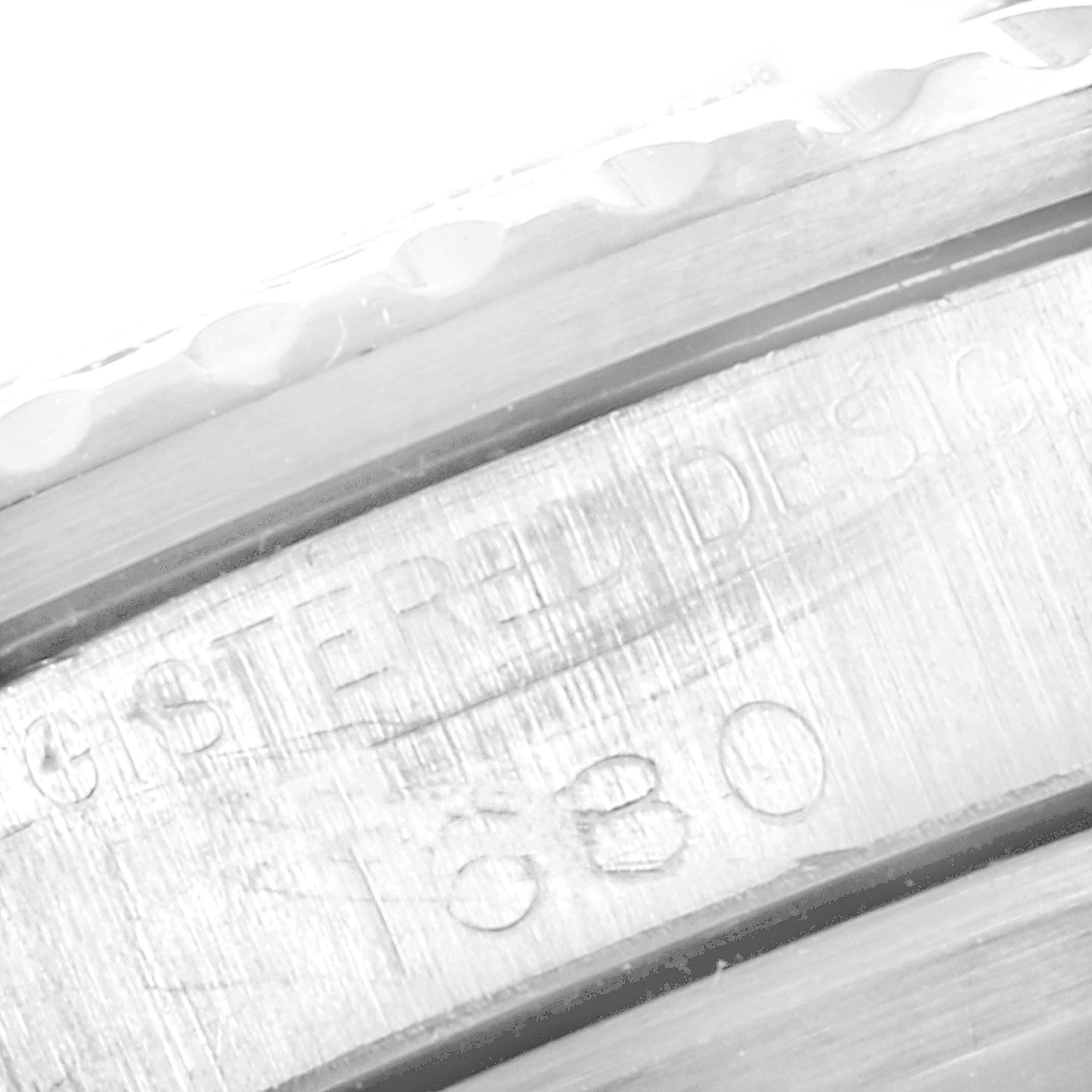 This close-up of the Rolex Vintage Collection 1680 Men's Stainless Steel Black Dial 1680 Men's Stainless Steel Black Dial watch shows part of the metal bezel with engraved markings.