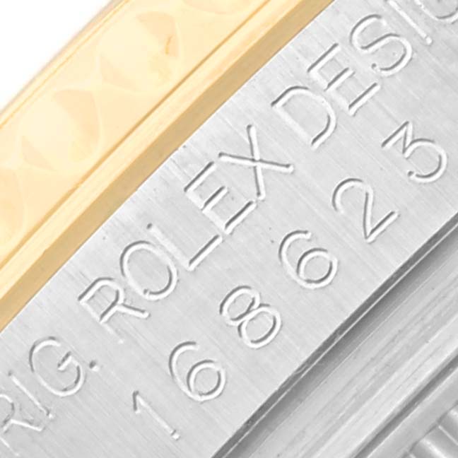 The image shows a close-up of the Rolex Yacht-Master 168623 Men's Steel and Gold (two tone) Grey Dial 168623 Men's Steel and Gold (two tone) Grey Dial's case side, featuring the engraving "ROLEX DESIGN" and model number.