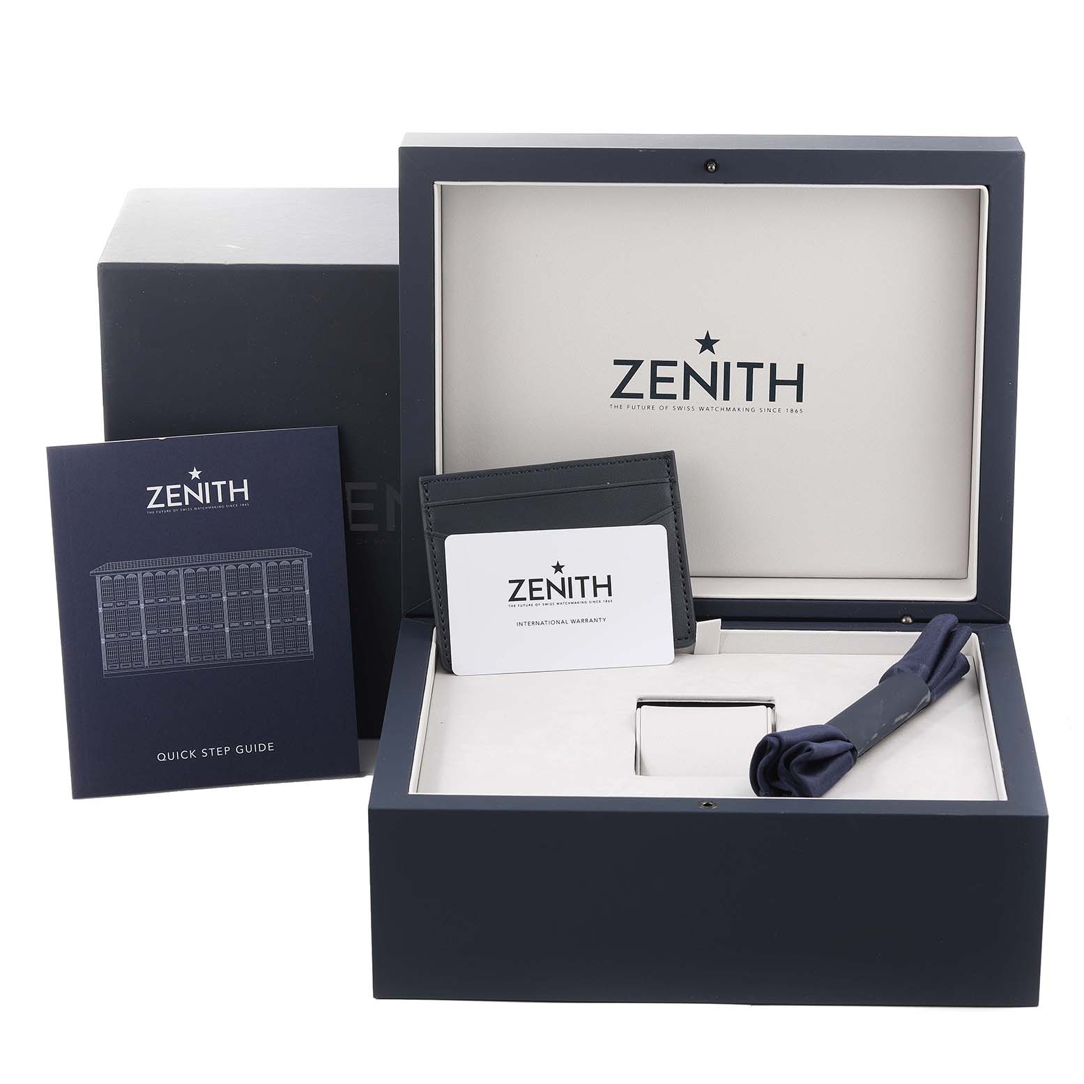 This image shows a Zenith Chronomaster 03.3105.3600 Men's Stainless Steel Blue Dial 03.3105.3600 Men's Stainless Steel Blue Dial watch box, quick step guide, warranty cardholder, and a cloth, from a top-down angle.