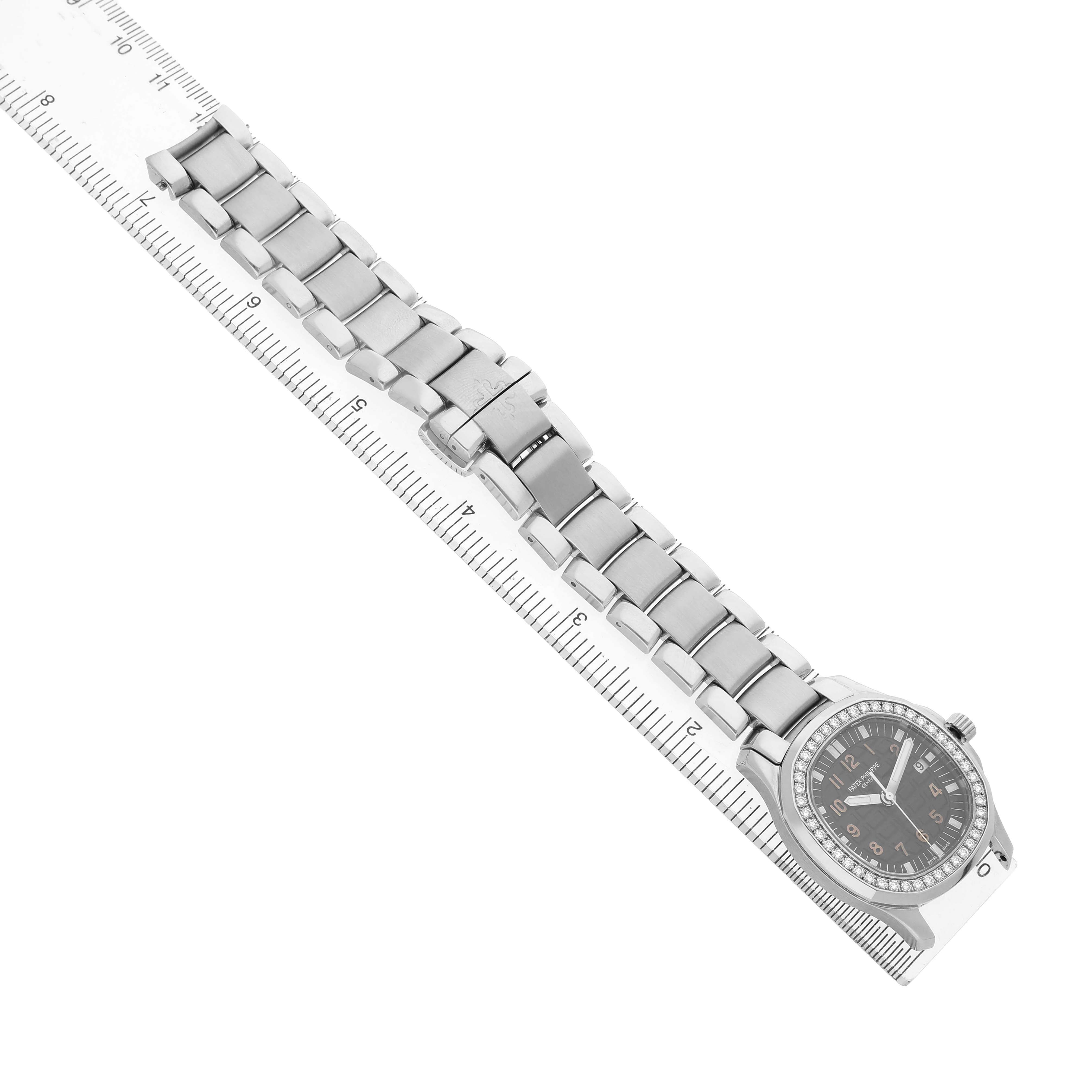 The Patek Philippe Aquanaut 5087/1A-001 Women's Stainless Steel Black Dial watch is shown from an overhead angle, displaying the full metal bracelet and watch face along a ruler.