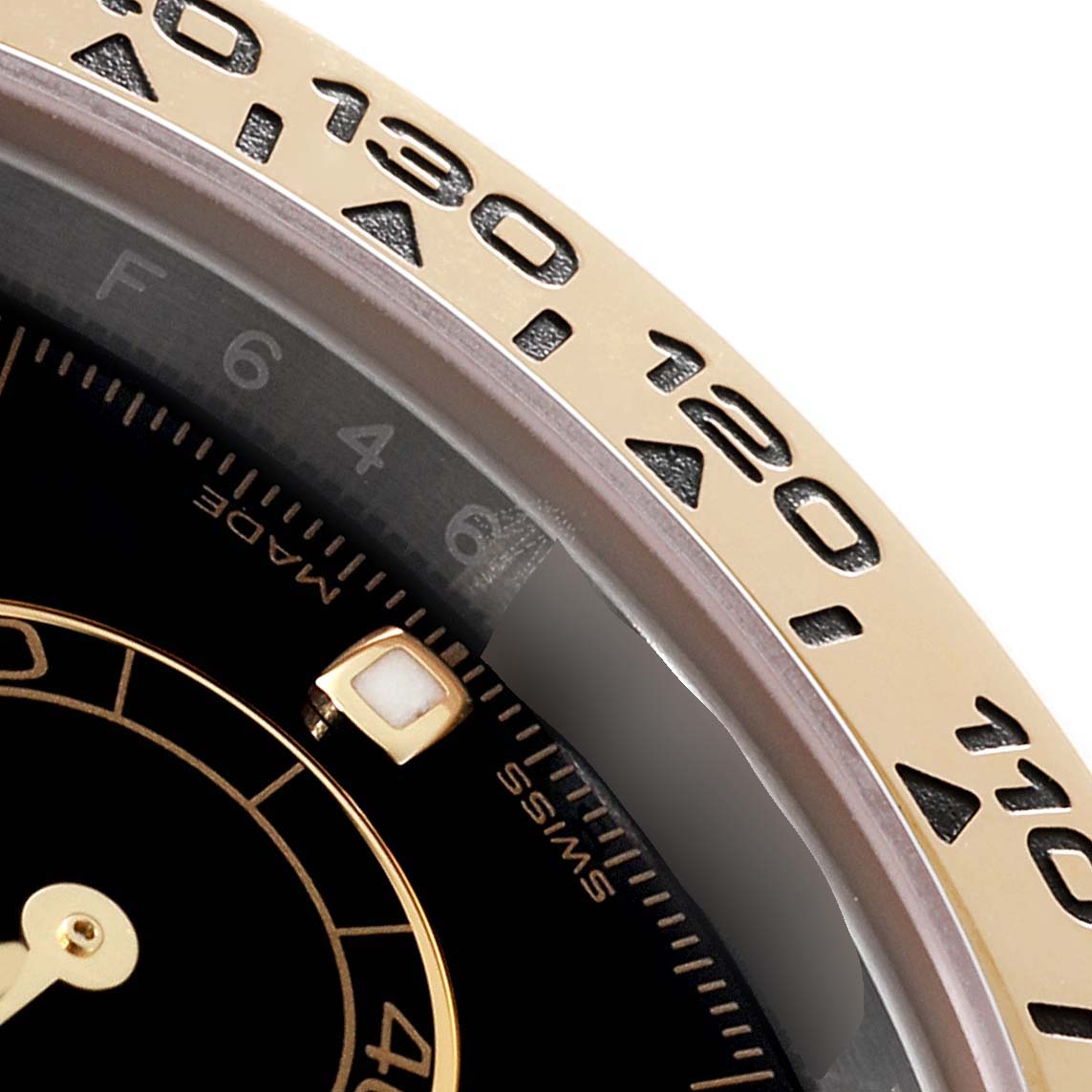 This image shows a close-up of the dial, bezel, and a marker on the Rolex Daytona 116503 Men's Steel and Gold (two tone) Black Dial 116503 Men's Steel and Gold (two tone) Black Dial watch.