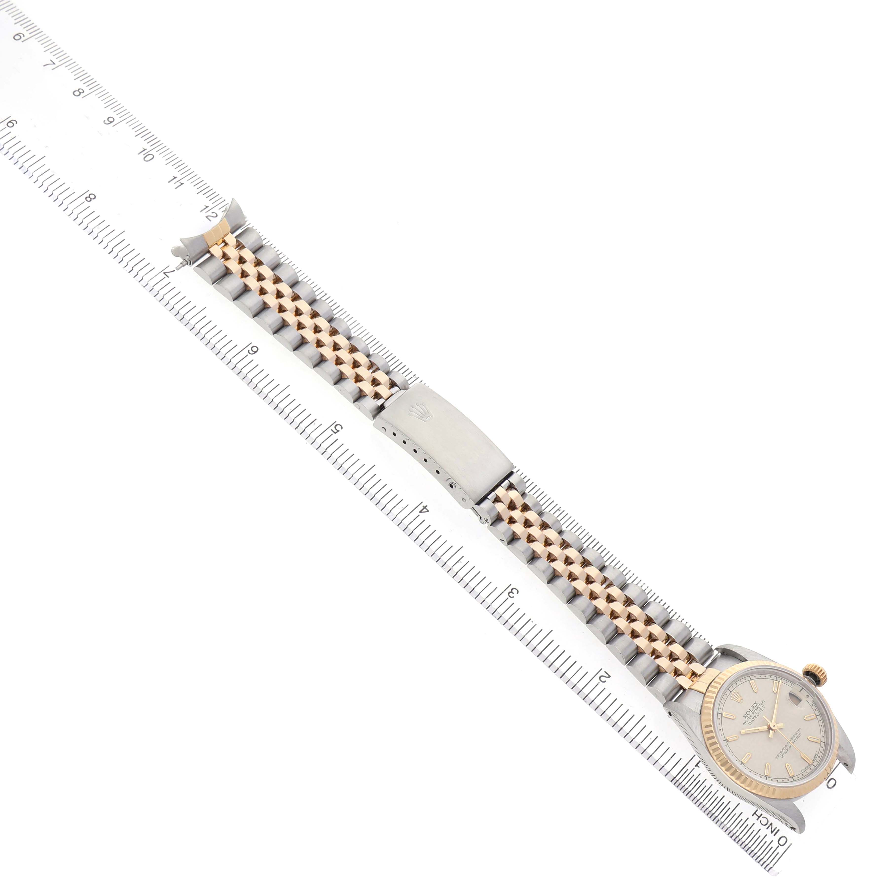 The Rolex Mid-Size 68273 Women's Steel and Gold (two tone) White Dial watch is displayed flat with the full bracelet and clasp visible alongside a ruler for scale.