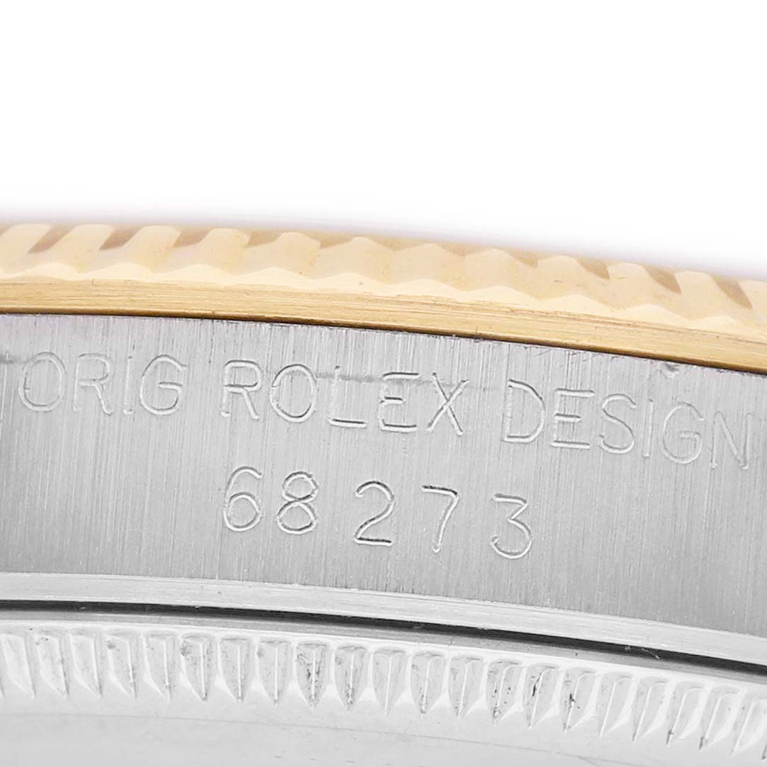 The image shows a close-up of the side of a Rolex Mid-Size 68273 Women's Steel and Gold (two tone) White Dial watch, highlighting the engraved model number and the edge of the bezel.