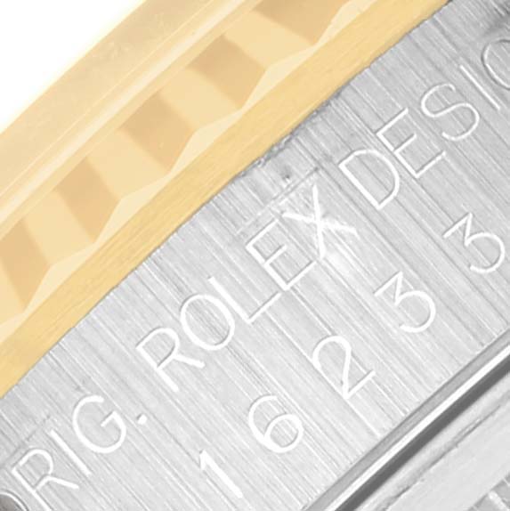 The image shows a close-up of the bezel and engraved edge of the casing of a Rolex Datejust 16233 Men's Steel and Gold (two tone) Beige Dial 16233 Men's Steel and Gold (two tone) Beige Dial watch.