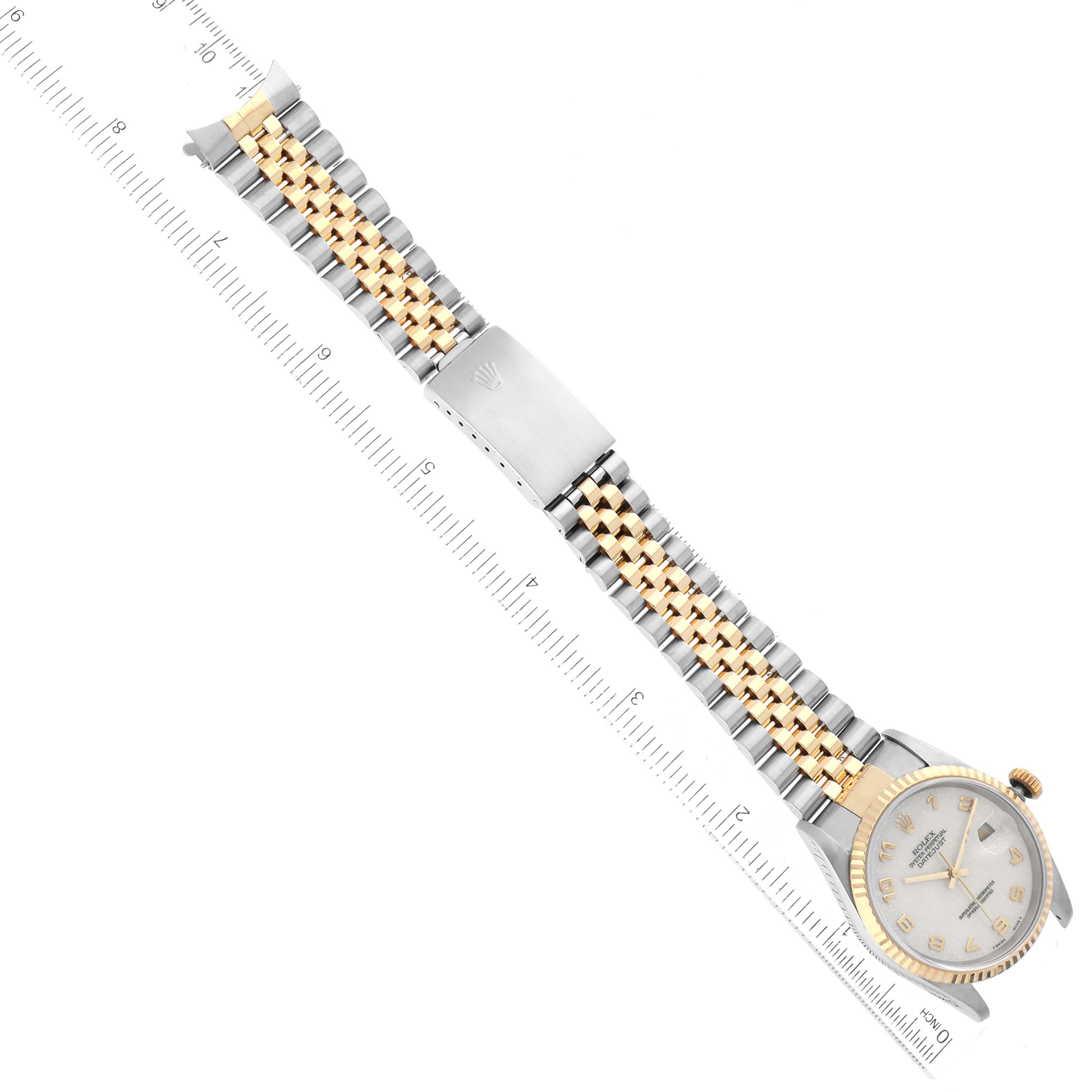 The image shows a top-down view of a Rolex Datejust 16233 Men's Steel and Gold (two tone) Beige Dial 16233 Men's Steel and Gold (two tone) Beige Dial watch, highlighting its bracelet, clasp, and face next to a ruler for scale.