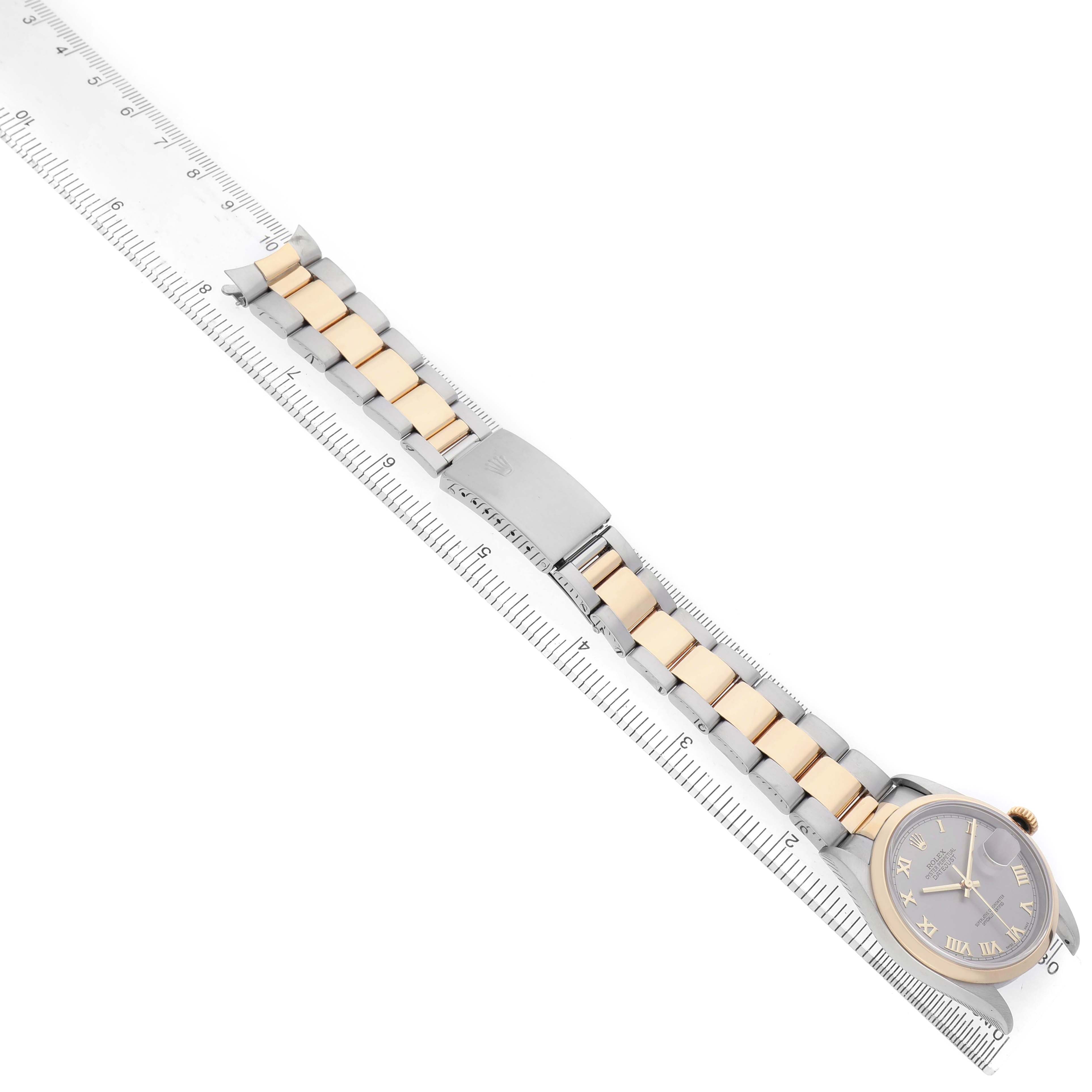 The Rolex Datejust 16203 Men's Steel and Gold (two tone) Silver Dial watch is shown diagonally with its bracelet and clasp displayed alongside a ruler for scale.