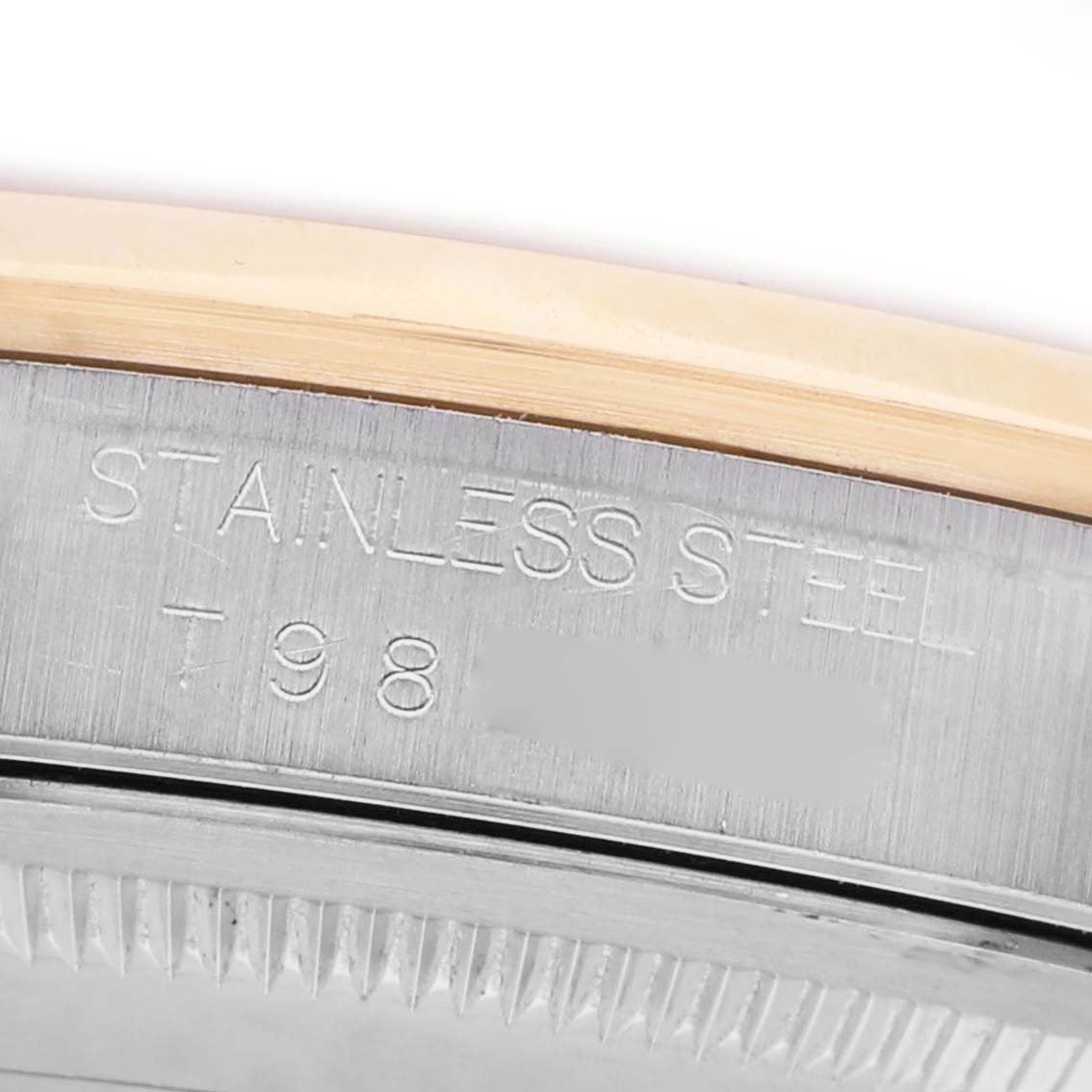 The image shows a close-up of the case side and bezel of a Rolex Datejust 16203 Men's Steel and Gold (two tone) Silver Dial, focusing on an engraving and material detail.