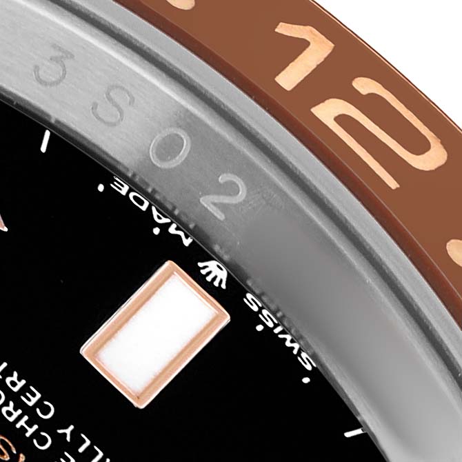 The image shows a close-up of the bezel and part of the dial on a Rolex GMT-Master 126711 Men's Steel and Gold (two tone) Black Dial watch.