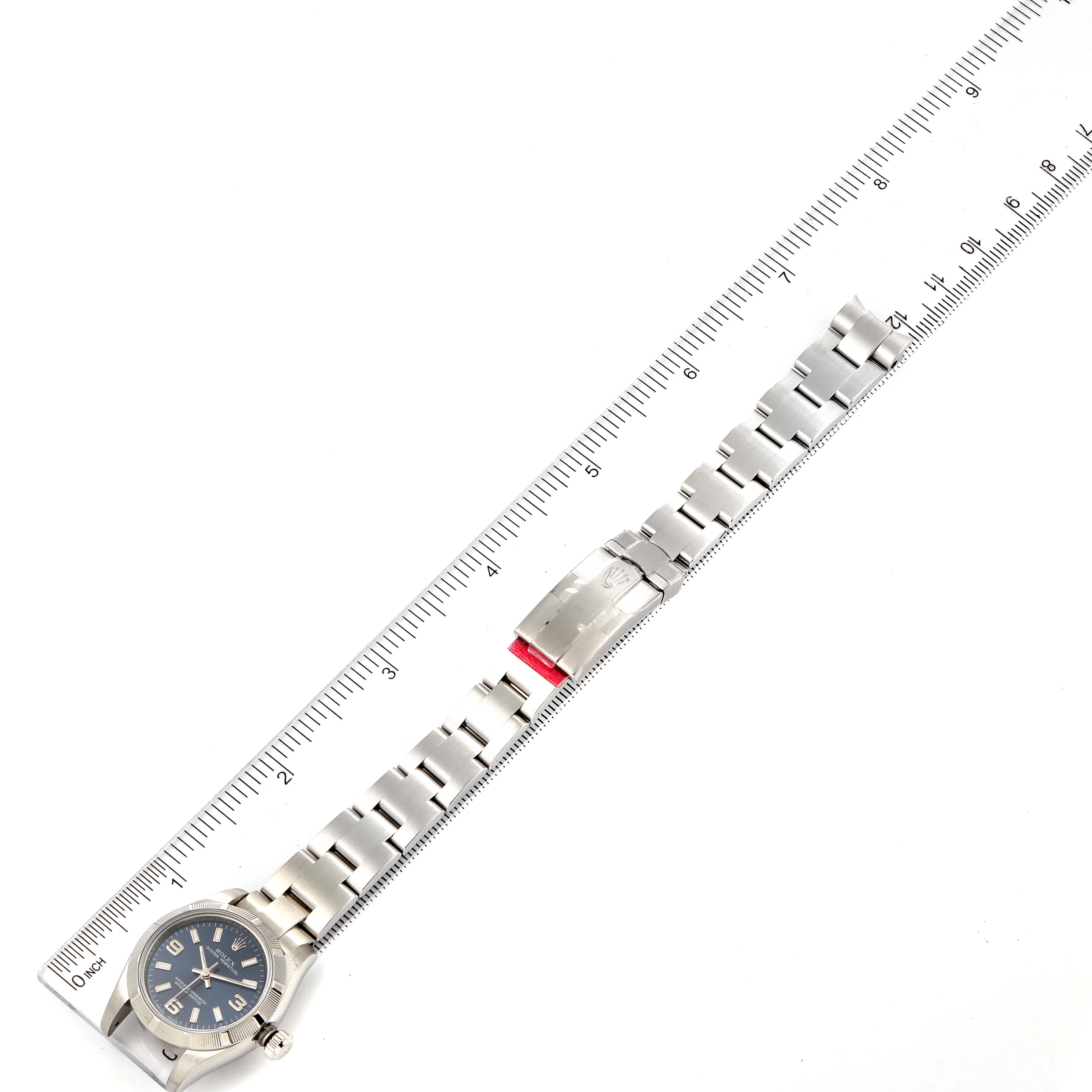 The Rolex Oyster Perpetual 176210 Women
s Stainless Steel Blue Dial 176210 Women
s Stainless Steel Blue Dial watch is laid flat, showcasing the entire bracelet and clasp alongside a ruler for measurement.
