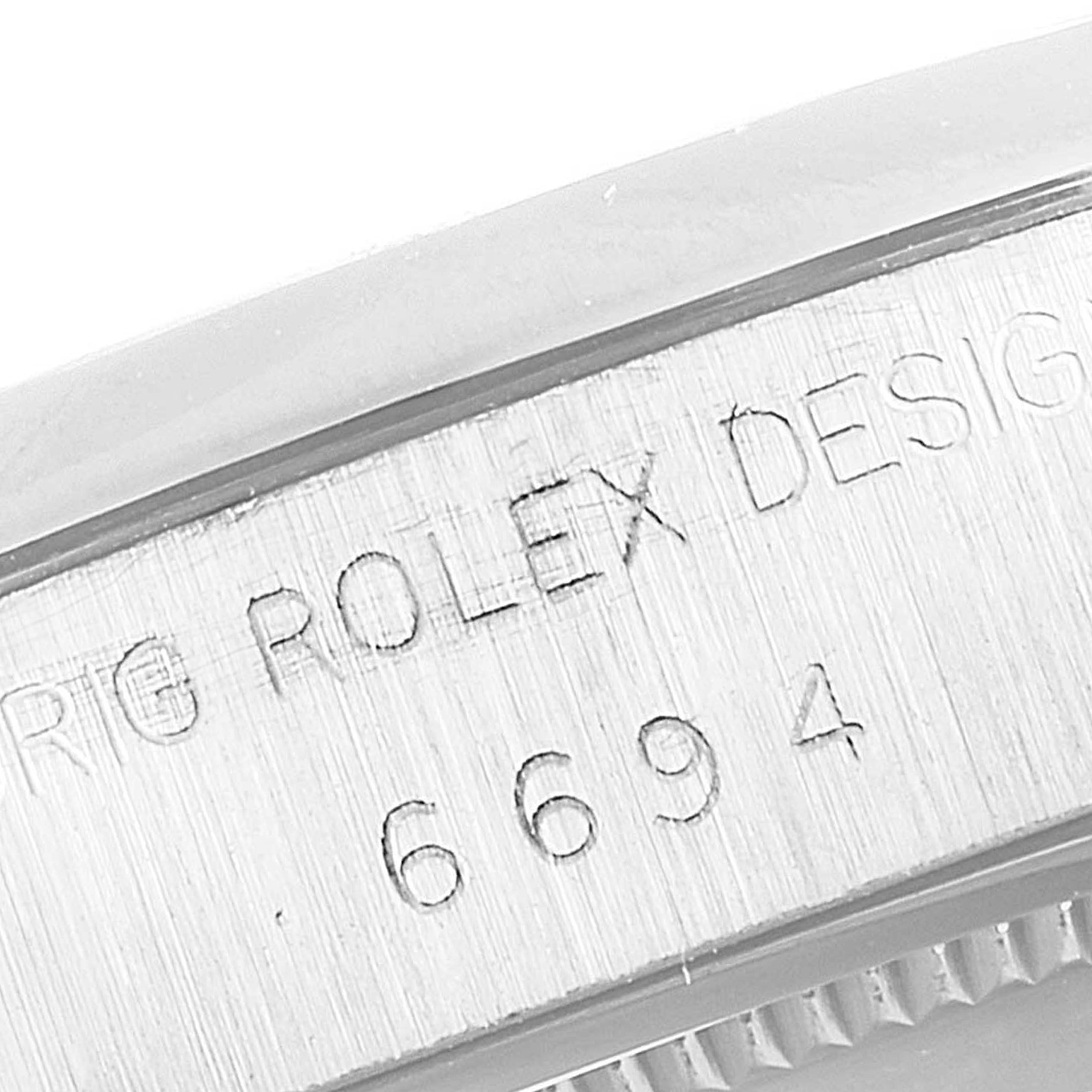 This close-up image shows the engraved case side of the Rolex Vintage Collection 6694 Men
s Stainless Steel Silver Dial 6694 Men
s Stainless Steel Silver Dial model, displaying "ROLEX DESIGN 6694."