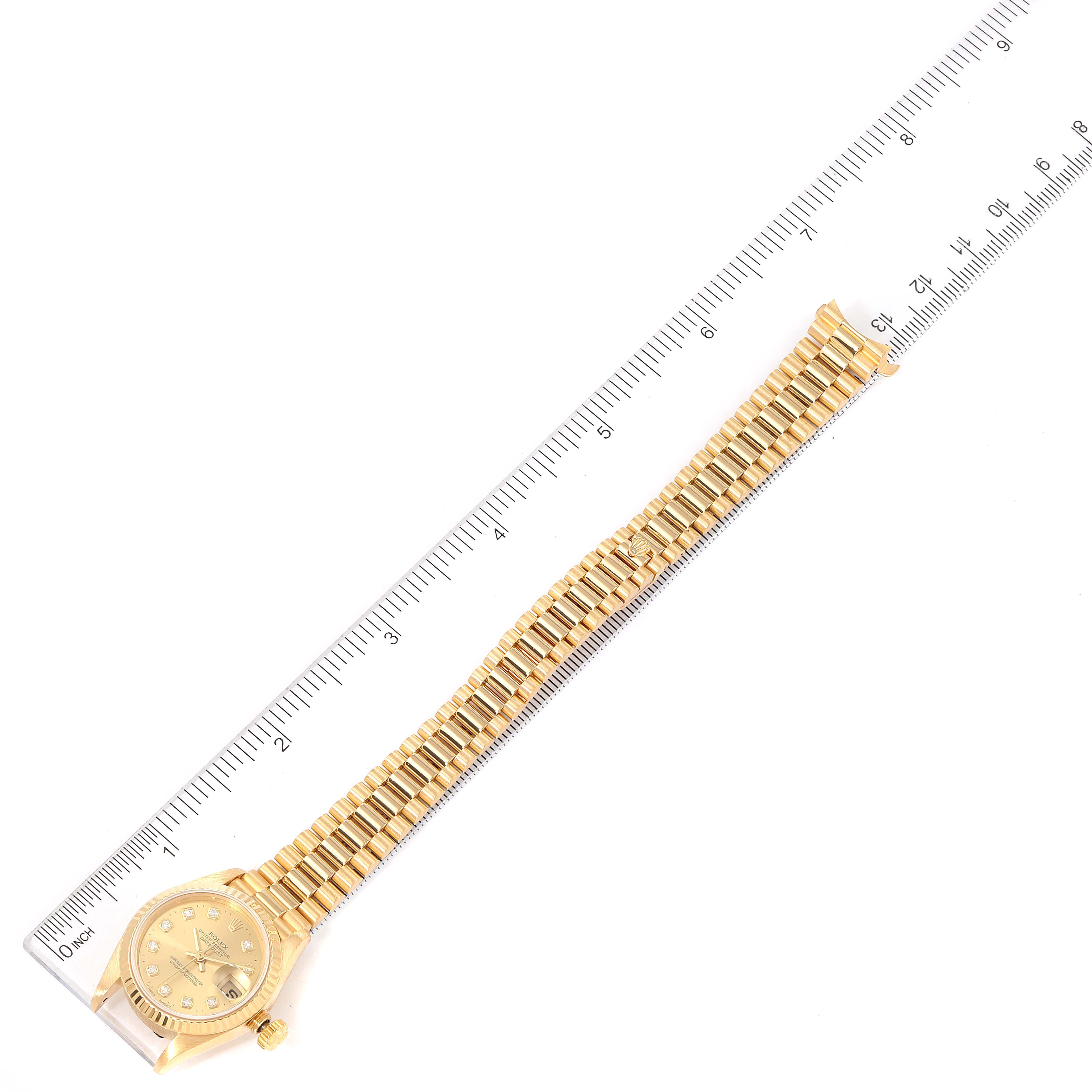 The image shows a Rolex President 69178 Women
s Yellow Gold Champagne Dial 69178 Women
s Yellow Gold Champagne Dial model watch laid flat alongside a ruler, highlighting the watch
s length.