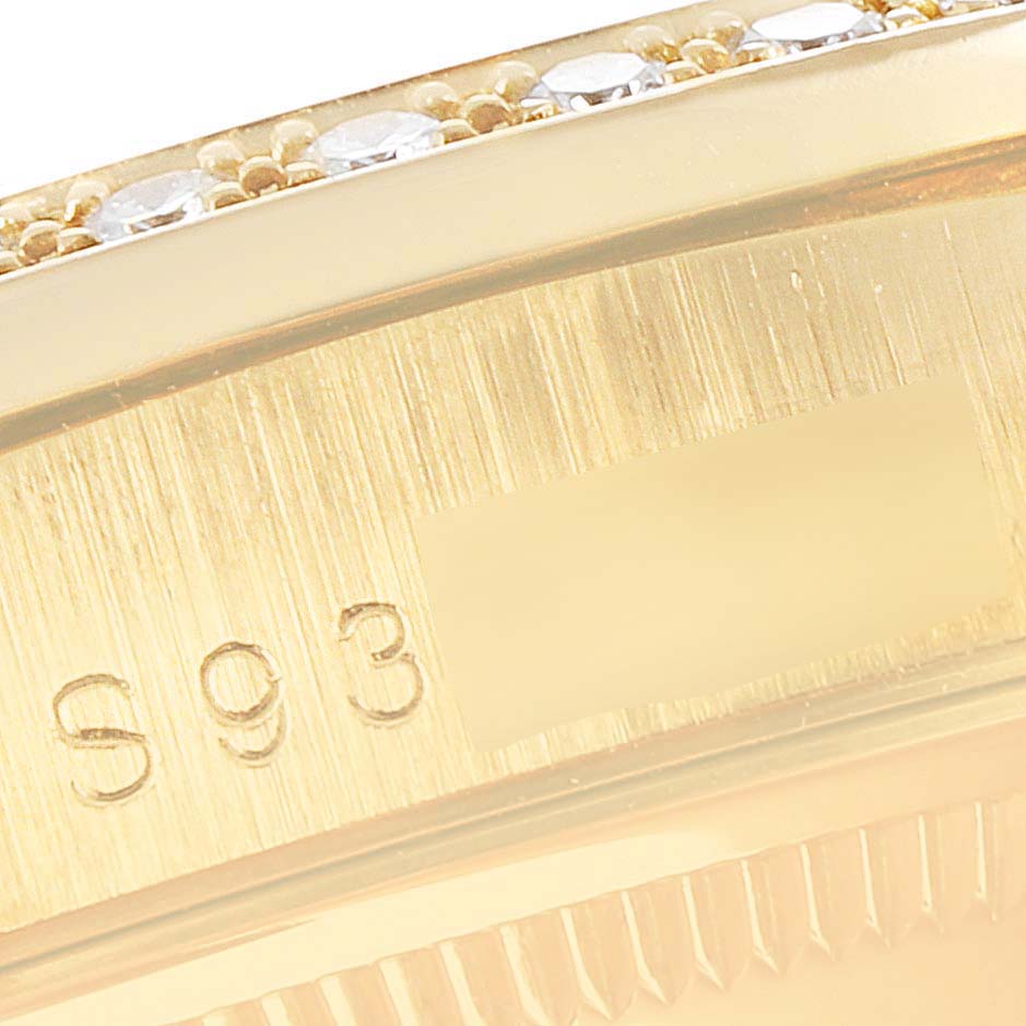The image shows a close-up of the side of a Rolex President 18388 Men
s Yellow Gold Black Dial 18388 Men
s Yellow Gold Black Dial model watch, focusing on the engraved numbers and part of the jeweled bezel.