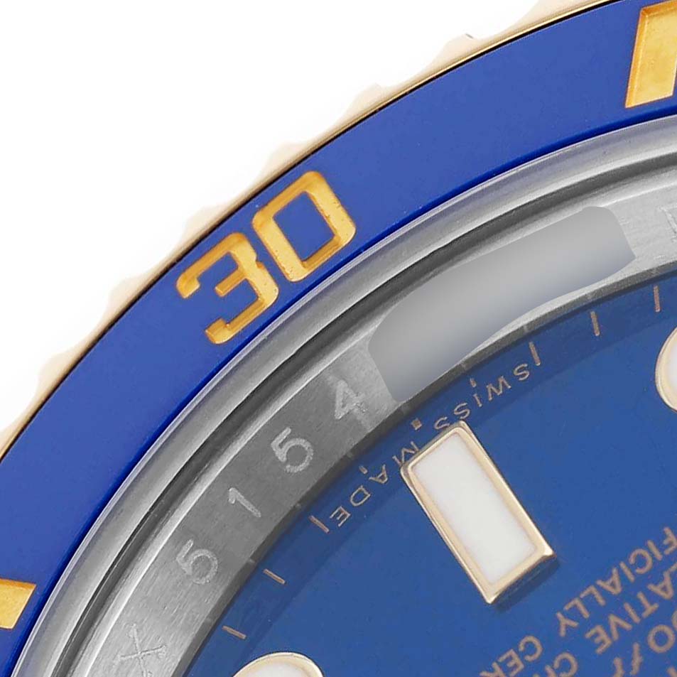The image shows a close-up of the blue and gold bezel and dial of the Rolex Submariner 116613 Men's Steel and Gold (two tone) Blue Dial watch at an oblique angle.