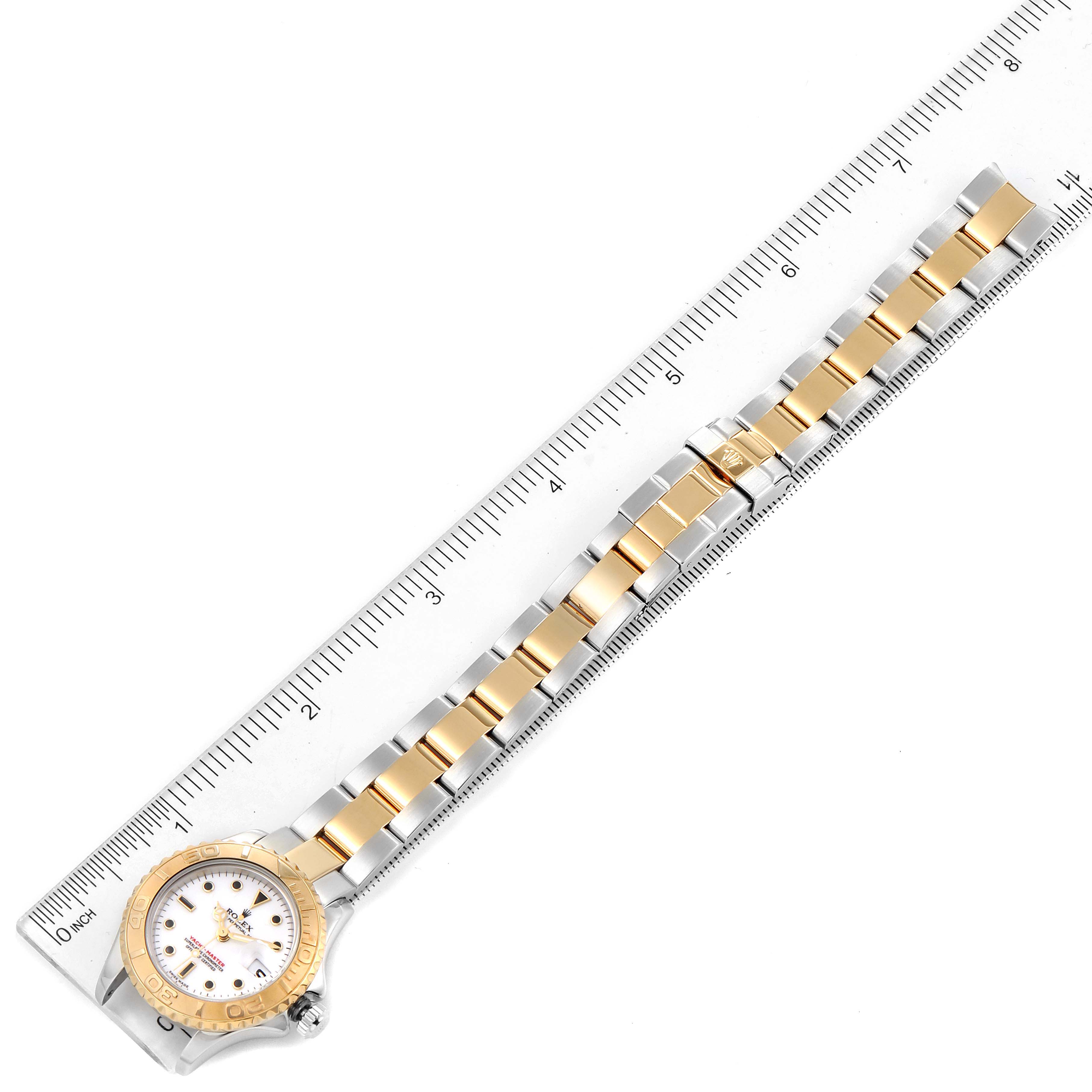 The image shows a Rolex Yacht-Master 169623 Women's Steel and Gold (two tone) White Dial 169623 Women's Steel and Gold (two tone) White Dial watch laid flat, showcasing its face, bezel, and two-tone bracelet alongside a ruler for scale.