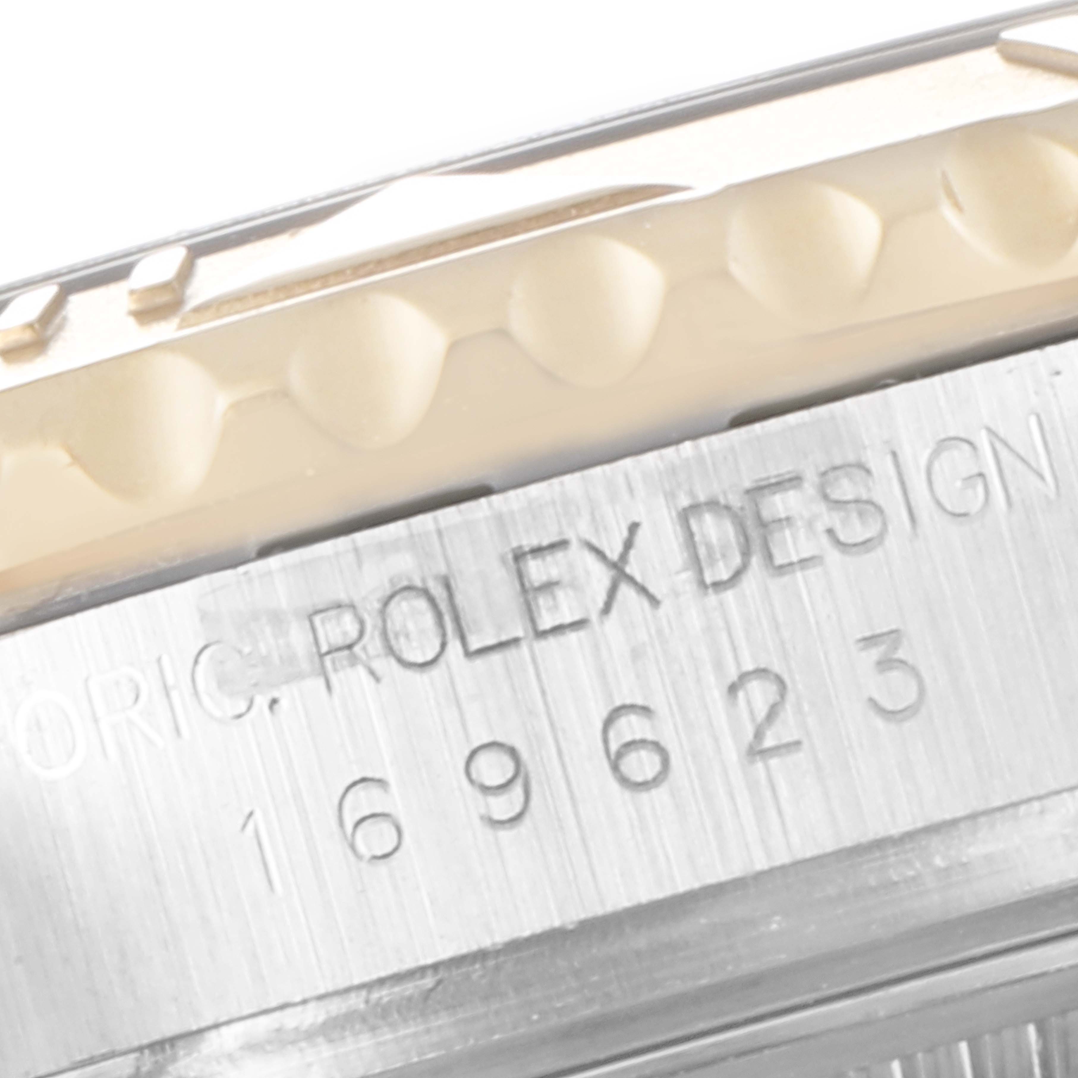 The image shows a close-up view of the side of a Rolex Yacht-Master 169623 Women's Steel and Gold (two tone) White Dial 169623 Women's Steel and Gold (two tone) White Dial watch case, featuring part of the bezel and serial number engraving.