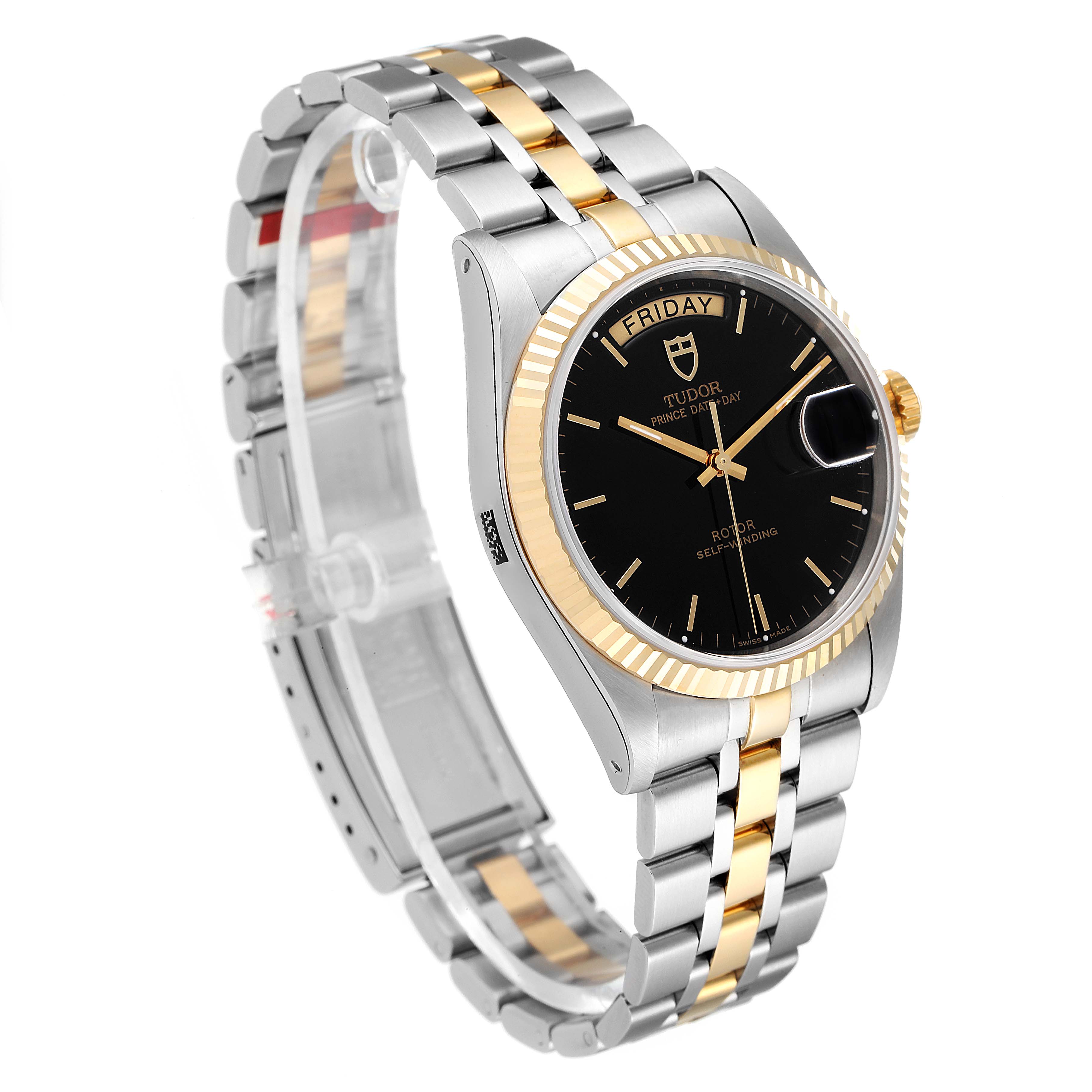 The image shows a Tudor Prince 76213 Men's Steel and Gold (two tone) Black Dial 76213 Men's Steel and Gold (two tone) Black Dial model watch angled to display its black dial, gold bezel, and two-tone metal bracelet.