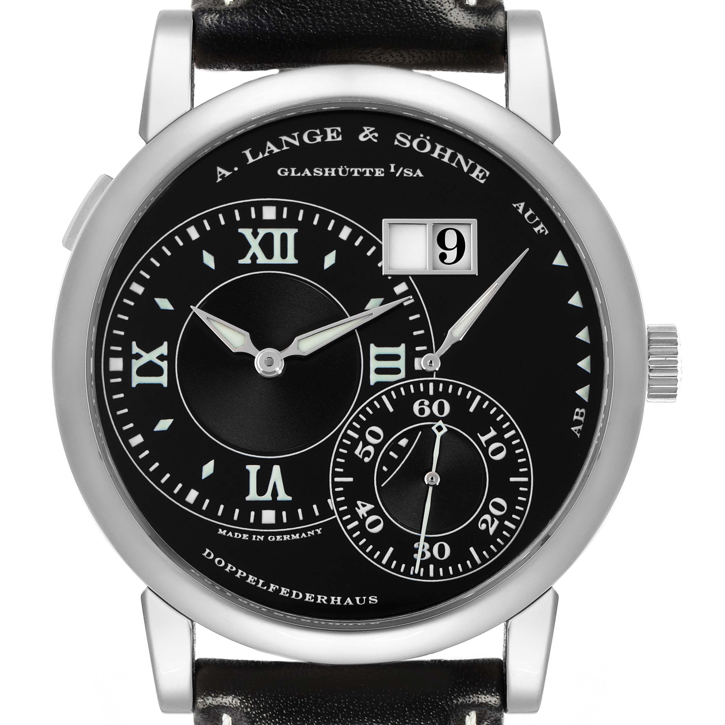 The image shows a frontal view of the A. Lange & Söhne Lange 1 model 115.029 men's watch, highlighting its black dial, Roman numerals, sub-dials, and date display.