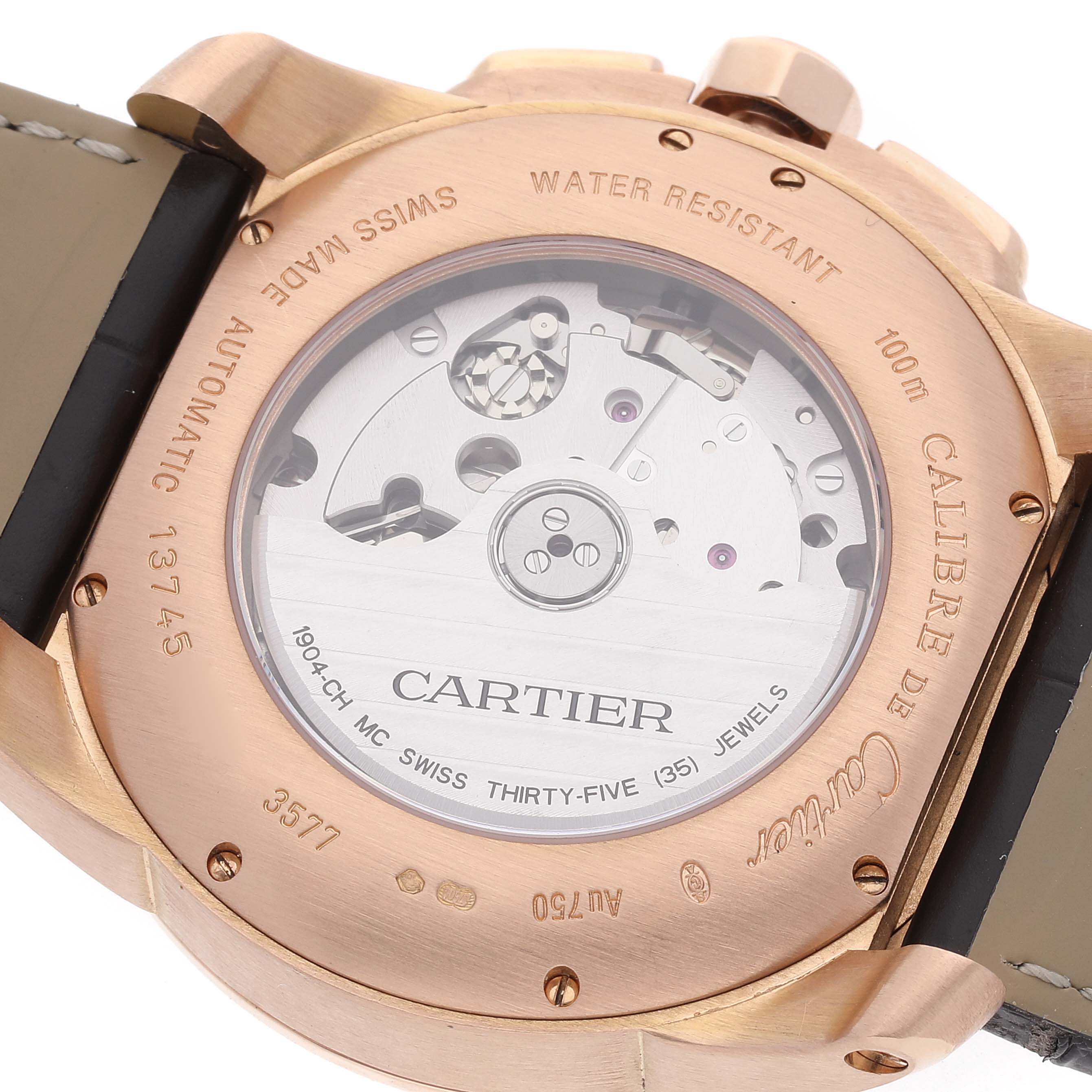 This image shows the back case of the Calibre de Cartier watch by Cartier, highlighting its movement and inscriptions.
