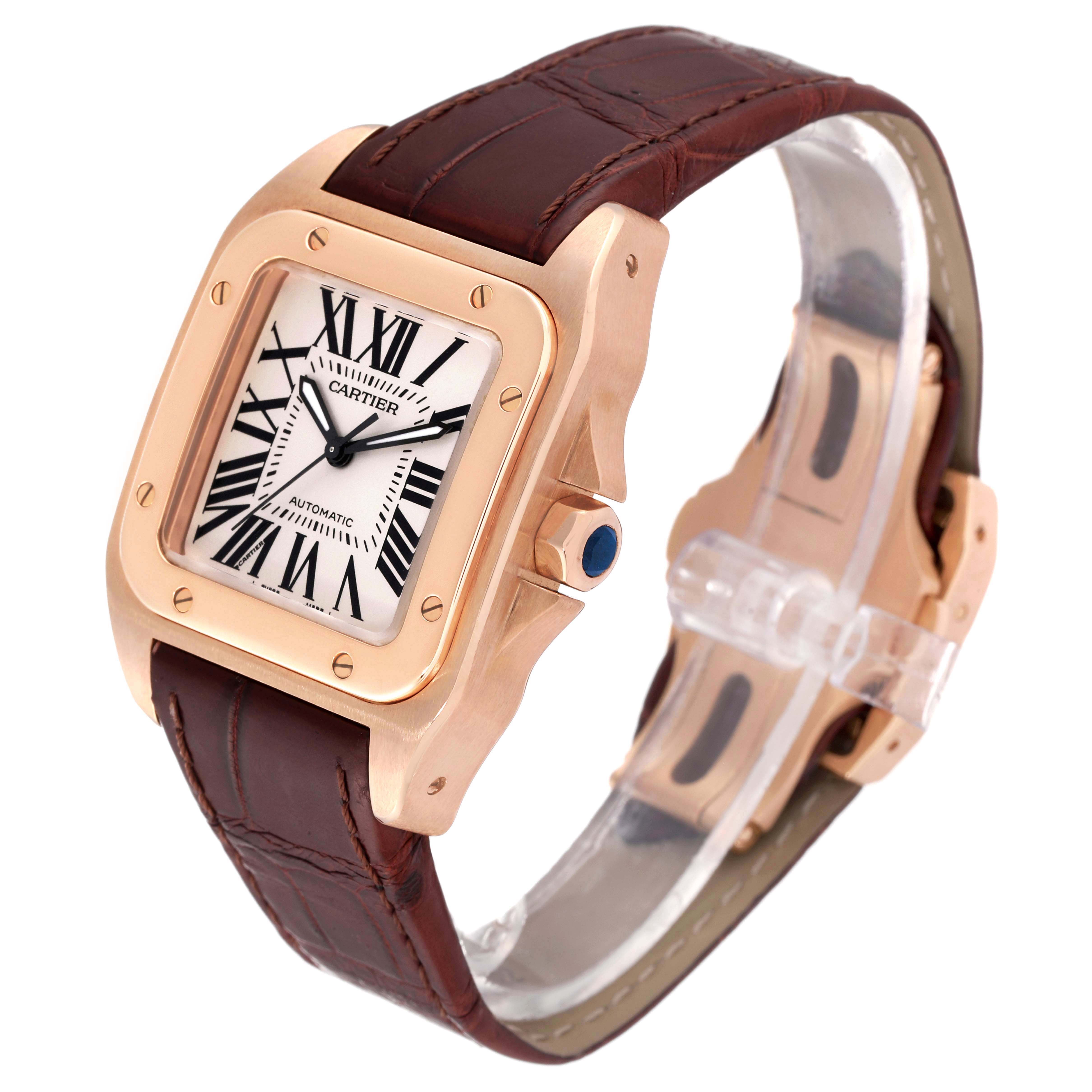 The Cartier Santos W20108Y1 Men's Rose Gold Silver Dial W20108Y1 Men's Rose Gold Silver Dial watch is shown at a slight angle showcasing the face, crown with blue gemstone, and brown leather strap.