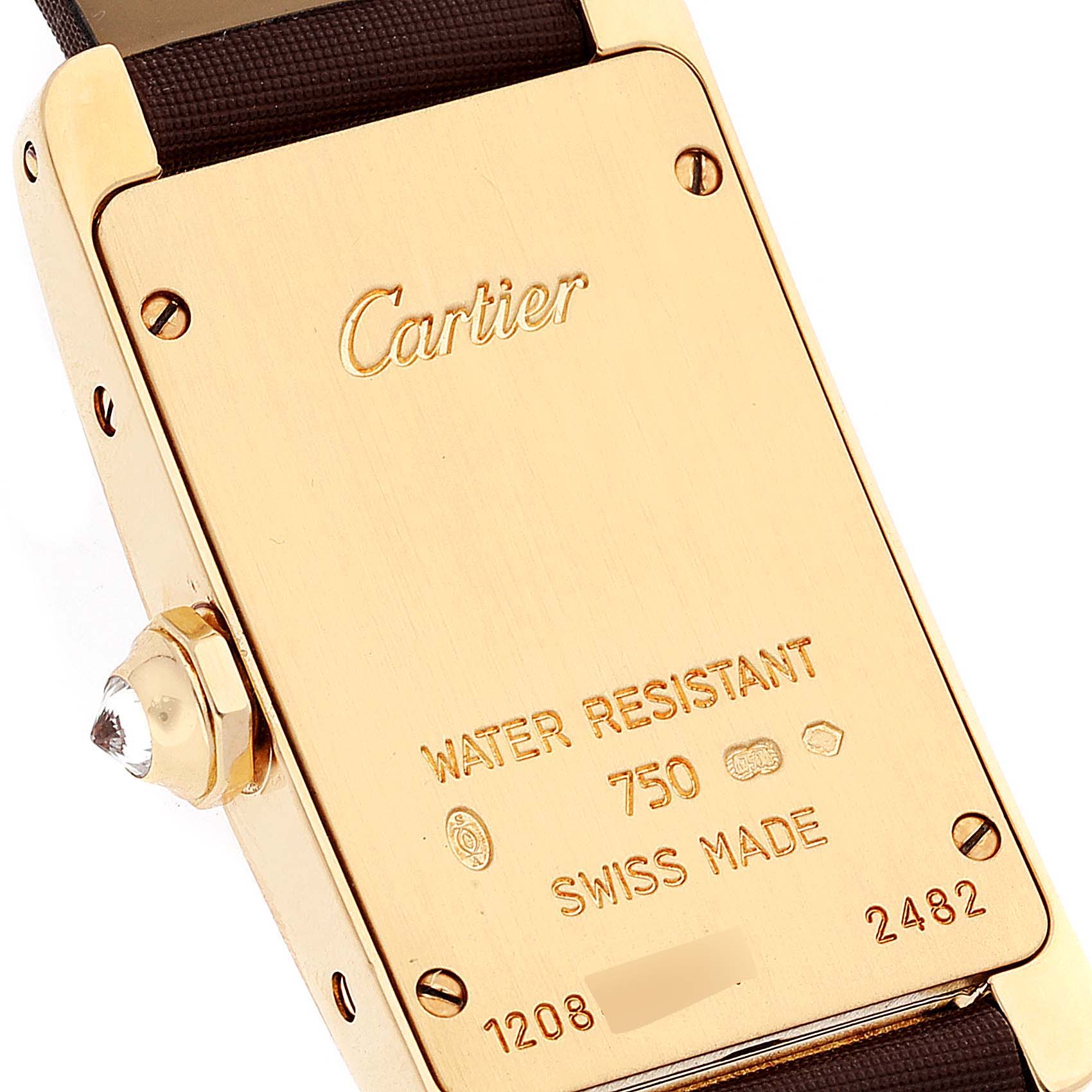 The image shows the back case and crown of a Tank Americaine watch by Cartier, highlighting the engraved details.