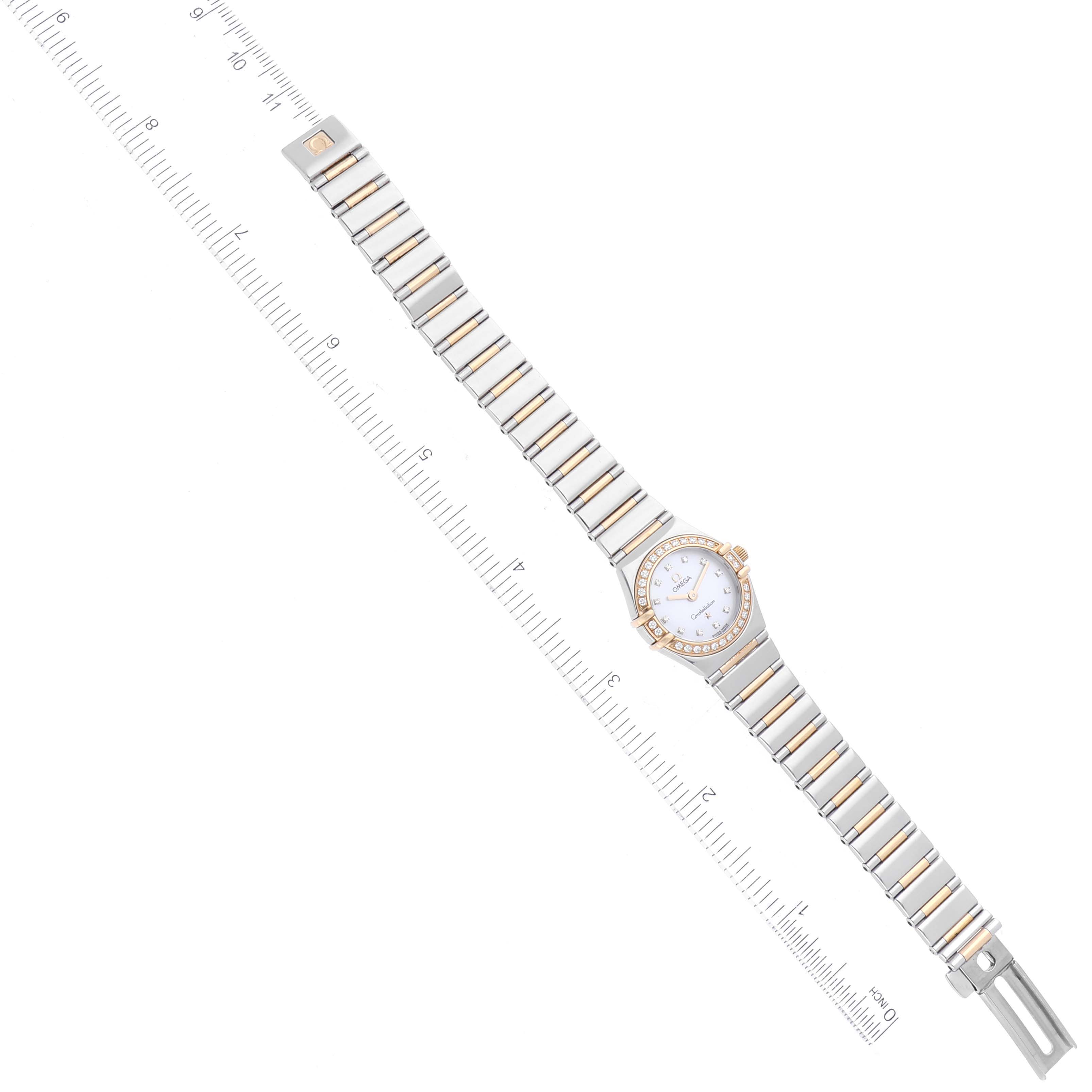 The image shows a top-down view of an Omega 1365.75.00 Women
s Steel and Gold (two tone) Mother of Pearl Dial 1365.75.00 Women
s Steel and Gold (two tone) Mother of Pearl Dial Constellation MOP Dial Diamond Ladies Watch 1365.75.00 with a ruler for scale.