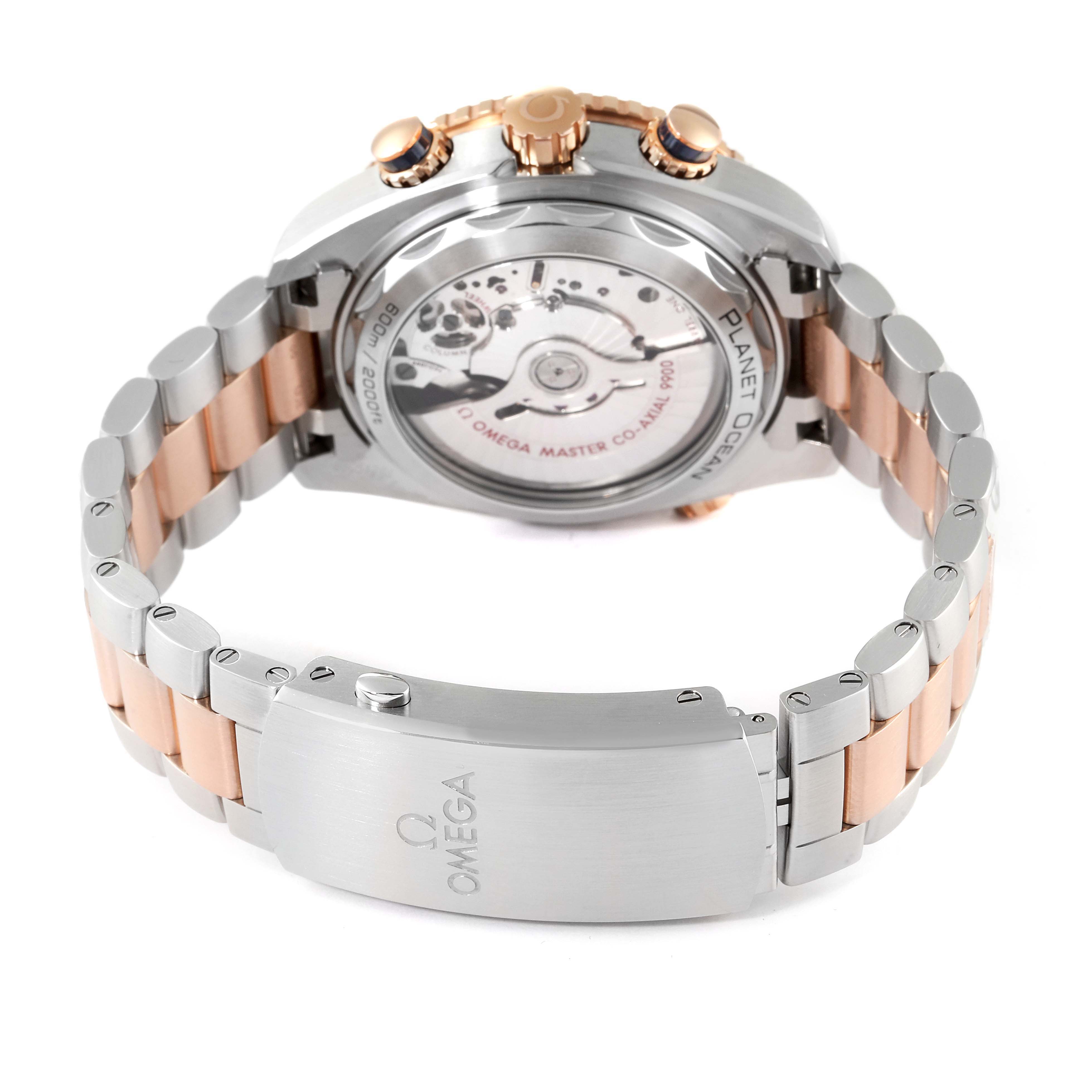 The image shows the back view of an Omega Planet Ocean 215.20.46.51.03.001 Men's Steel and Gold (two tone) Blue Dial 215.20.46.51.03.001 Men's Steel and Gold (two tone) Blue Dial watch, highlighting its movement and two-tone bracelet.