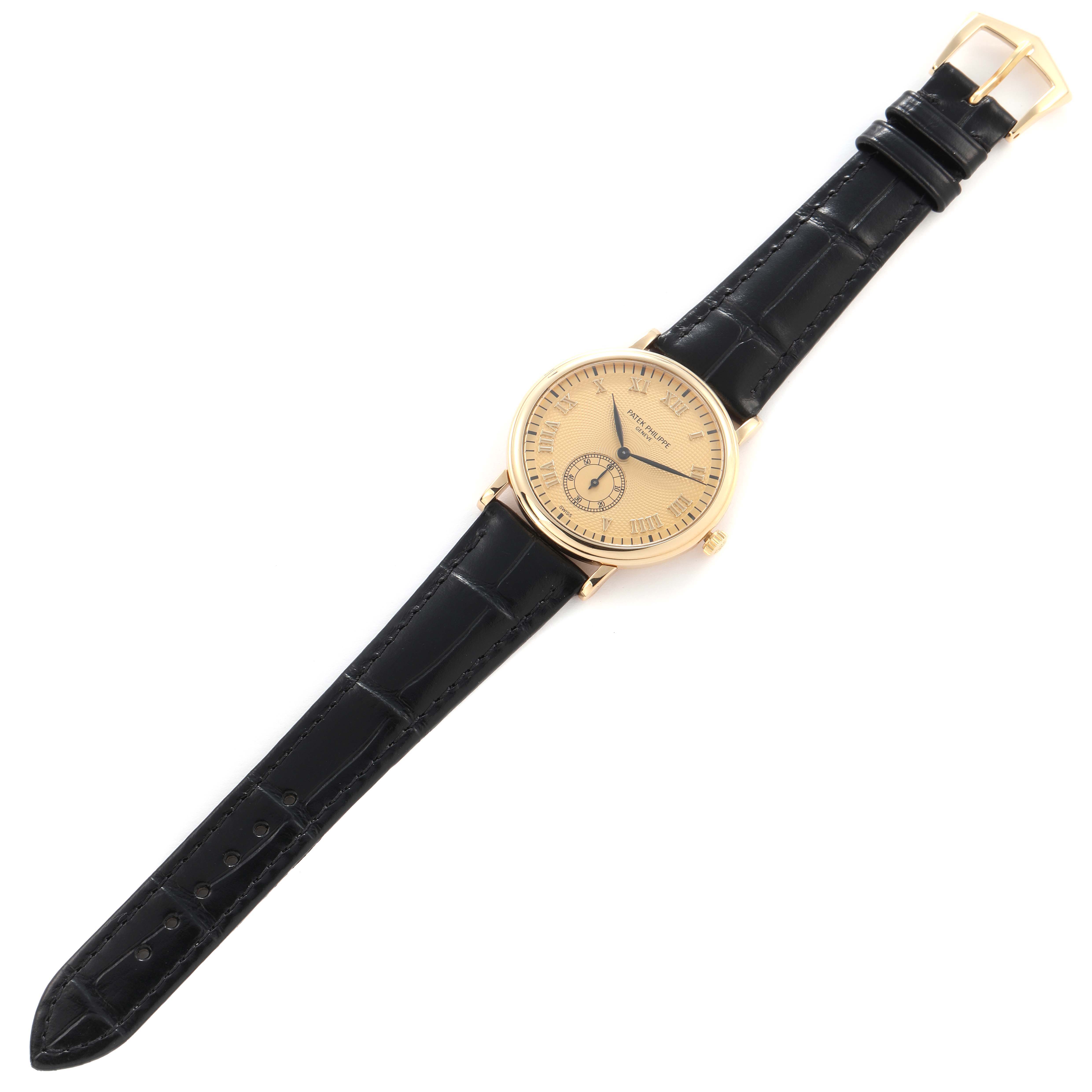 The Patek Philippe Calatrava 5022J-001 watch is shown at a slight angle, displaying its gold case, beige dial, black leather strap, and buckle.