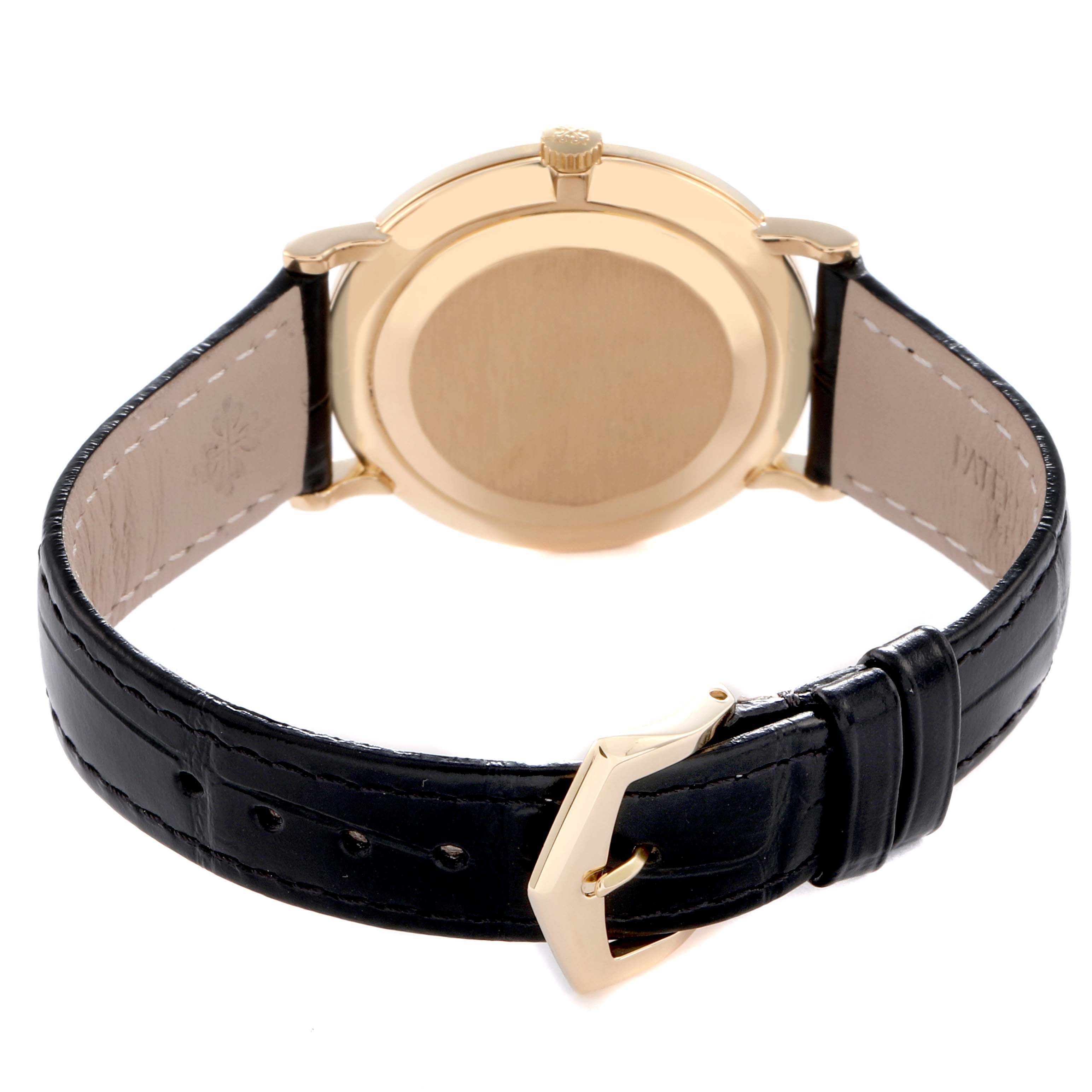 The image shows the back view of a Patek Philippe Calatrava model 5022J-001 men's watch, highlighting the gold case back, crown, and black leather strap with buckle.