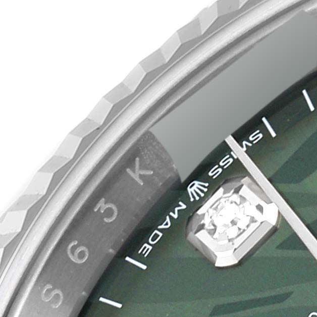 This close-up of a Rolex Datejust 126234 Men's Stainless Steel Green Dial 126234 Men's Stainless Steel Green Dial shows the bezel, partial dial, and a diamond marker.