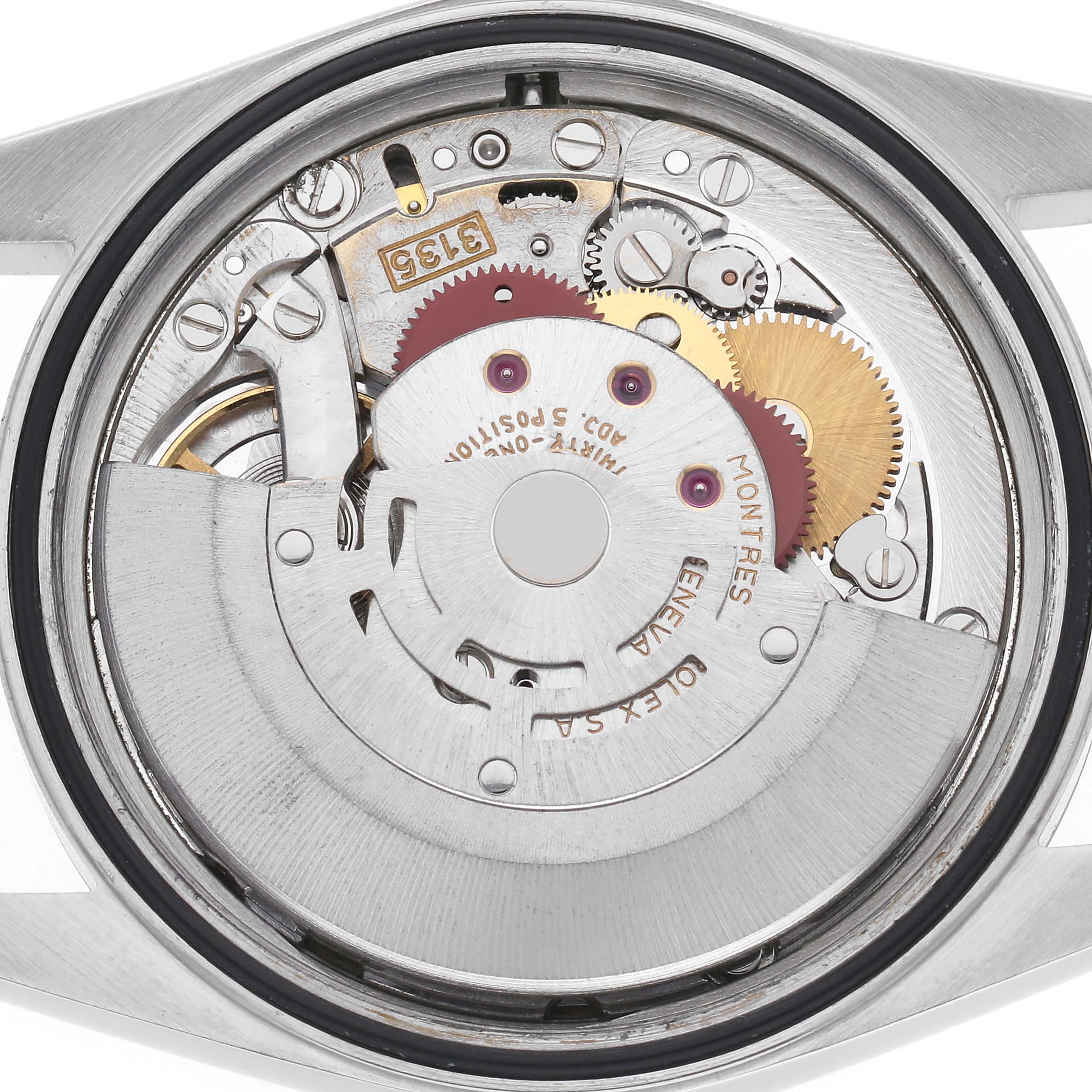 The image shows the movement mechanism inside the case of a Rolex Datejust model 16234 men's watch, viewed from the back, highlighting gears and components.