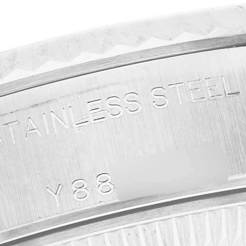 The image shows a close-up angle of the engraving on the case of a Rolex Datejust model 79174, highlighting the "STAINLESS STEEL" marking and partial serial number.