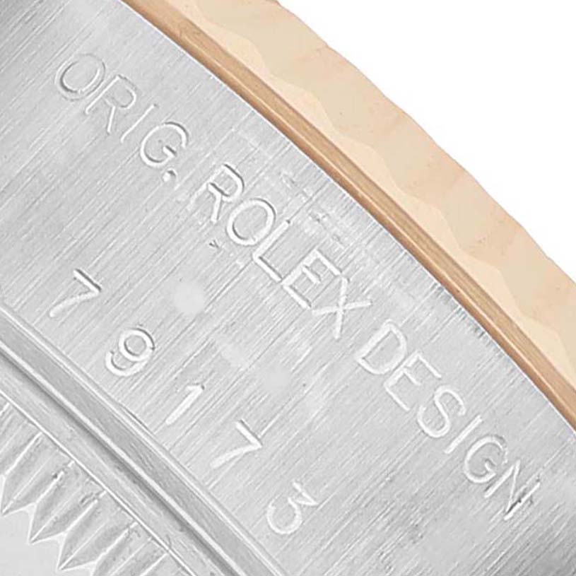 The image shows a close-up of the side of a Rolex Datejust 79173 Women's Steel and Gold (two tone) Blue Dial, featuring the engraved model number and bezel design.