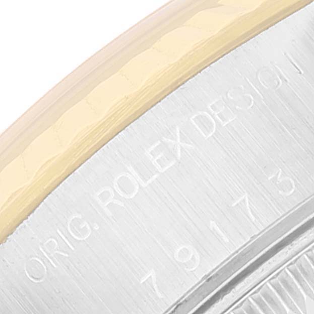 This close-up image shows the engraved edge of the casing on a Rolex Datejust 79173 Women's Steel and Gold (two tone) Silver Dial 79173 Women's Steel and Gold (two tone) Silver Dial watch.