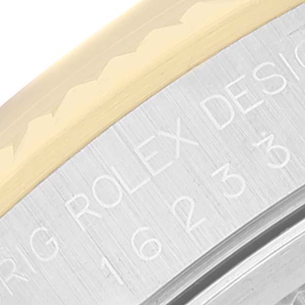 The image shows a close-up of the engraved bezel and fluted rim of a Rolex Datejust 16233 Men's Steel and Gold (two tone) Silver Dial 16233 Men's Steel and Gold (two tone) Silver Dial watch.