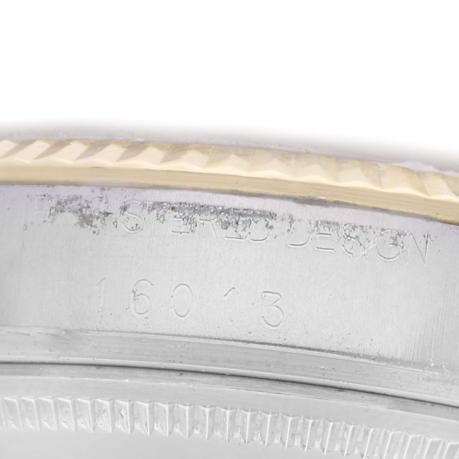 The image shows a close-up of the side and bezel of a Rolex Vintage Collection watch, model number 16013, highlighting the engraved details.